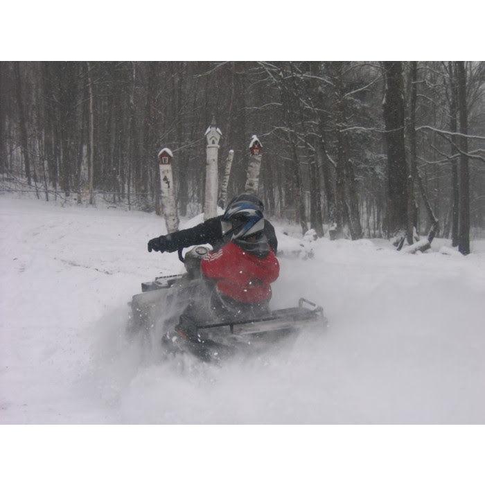 December 2006 - Forrest driving a four-wheeler in the snow in Vermont with Olivia on the back