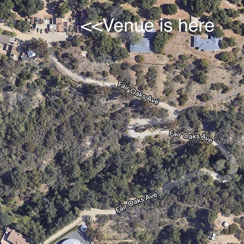 Maps pin takes you to the lower lot where you will park. From there, a shuttle will take you up the hill to the venue. 