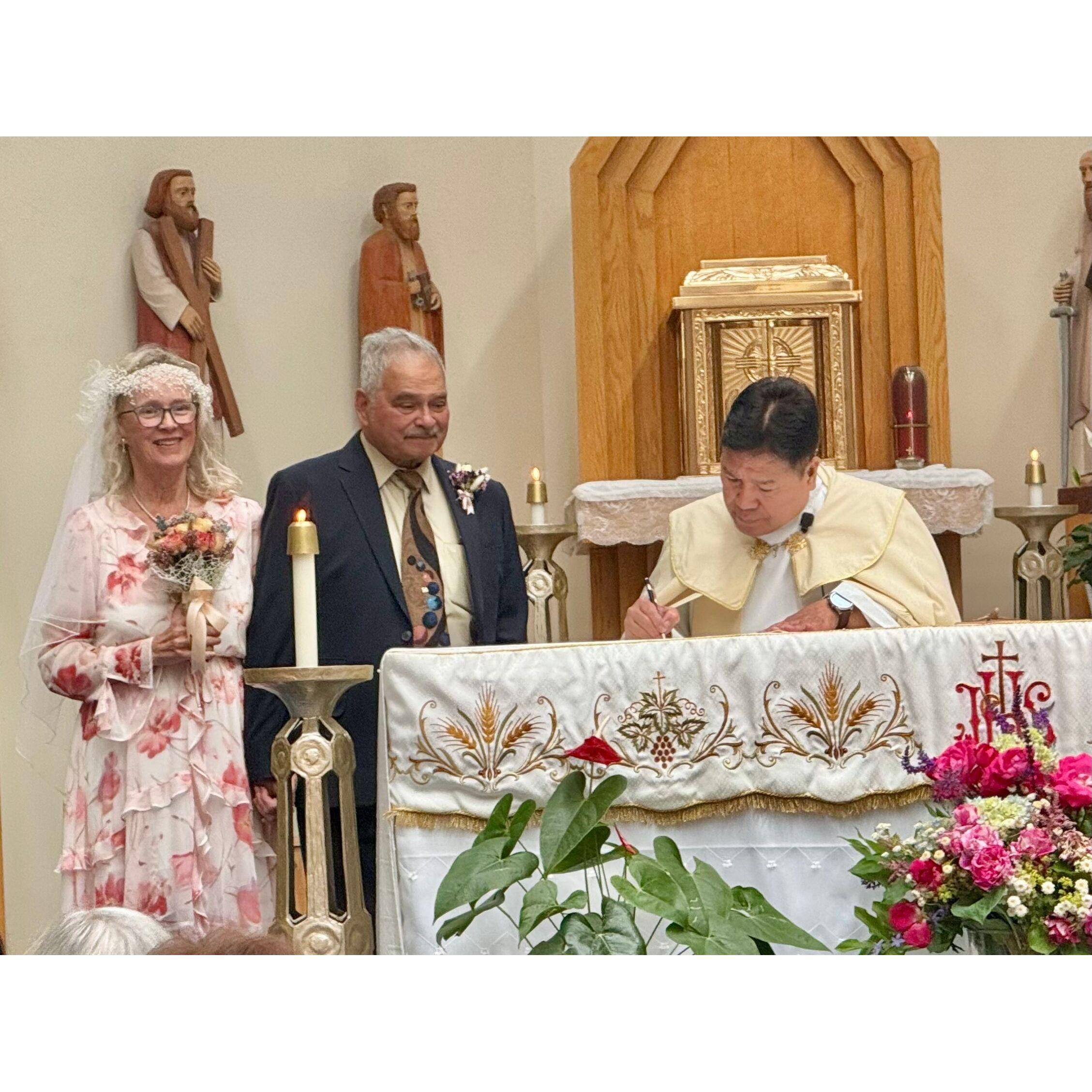 Father Abundo signs the register.