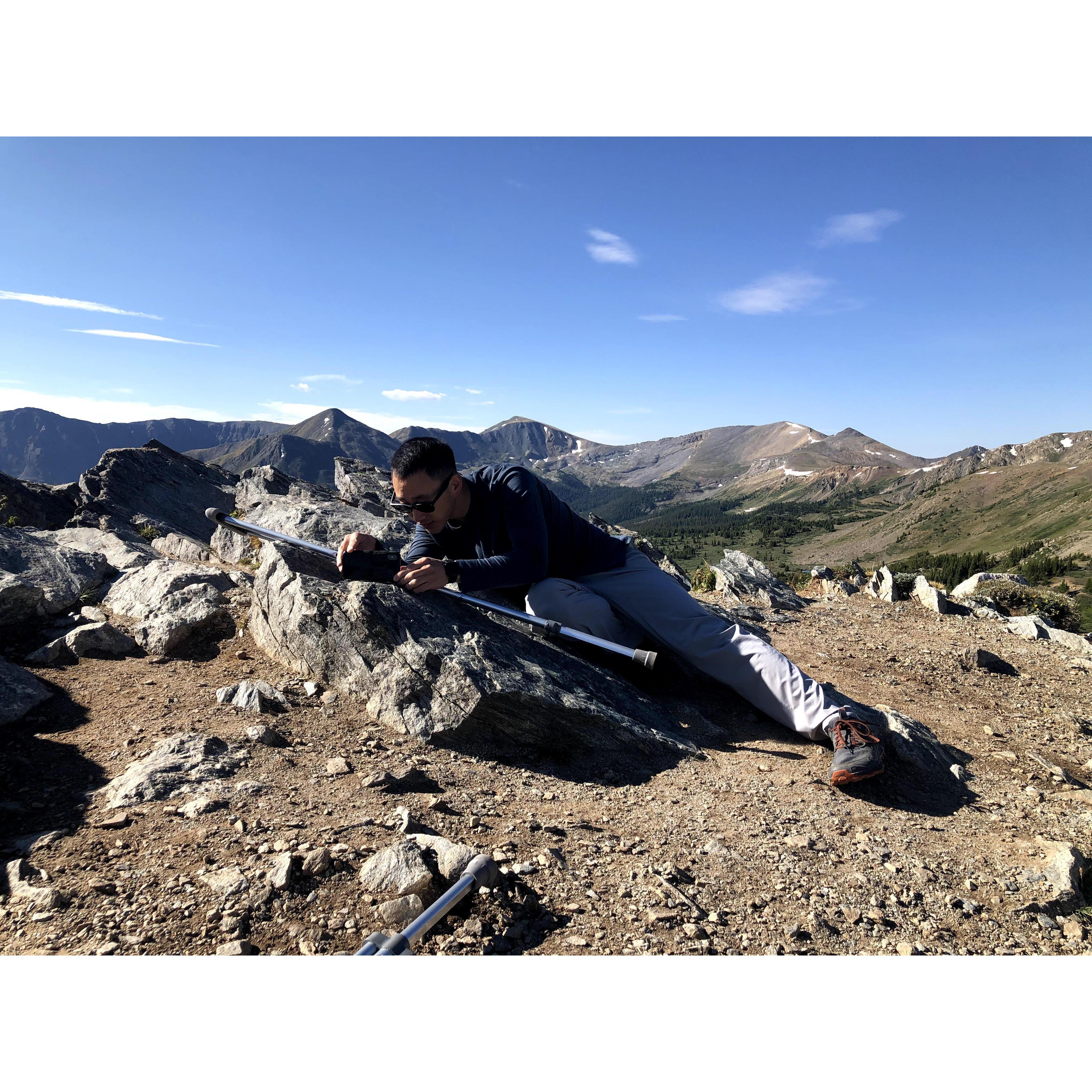 Peter using Emily's crutch and a rock as a makeshift tripod.