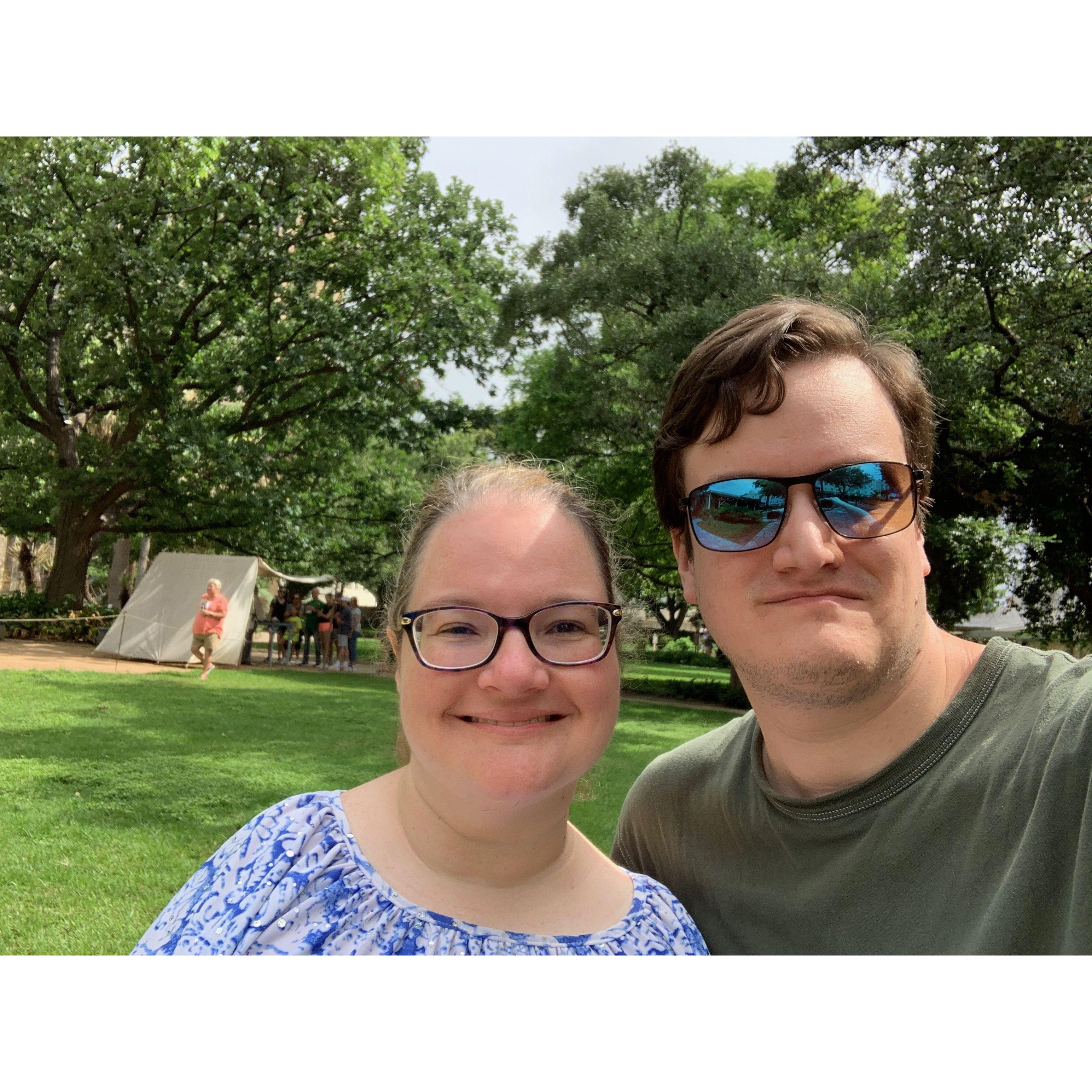 Selfie in a scenic and lush green park at the Alamo. The sun hits the couple so beautifully!