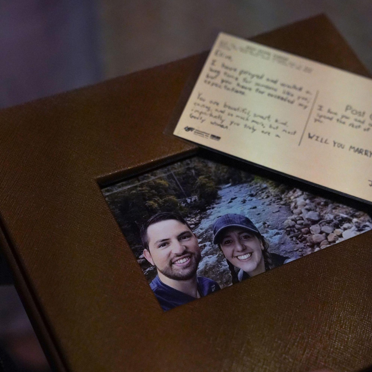 Josh proposed with a book of vintage postcards, which I collect. The last postcard he gave me had a special message, "Will you marry me?"