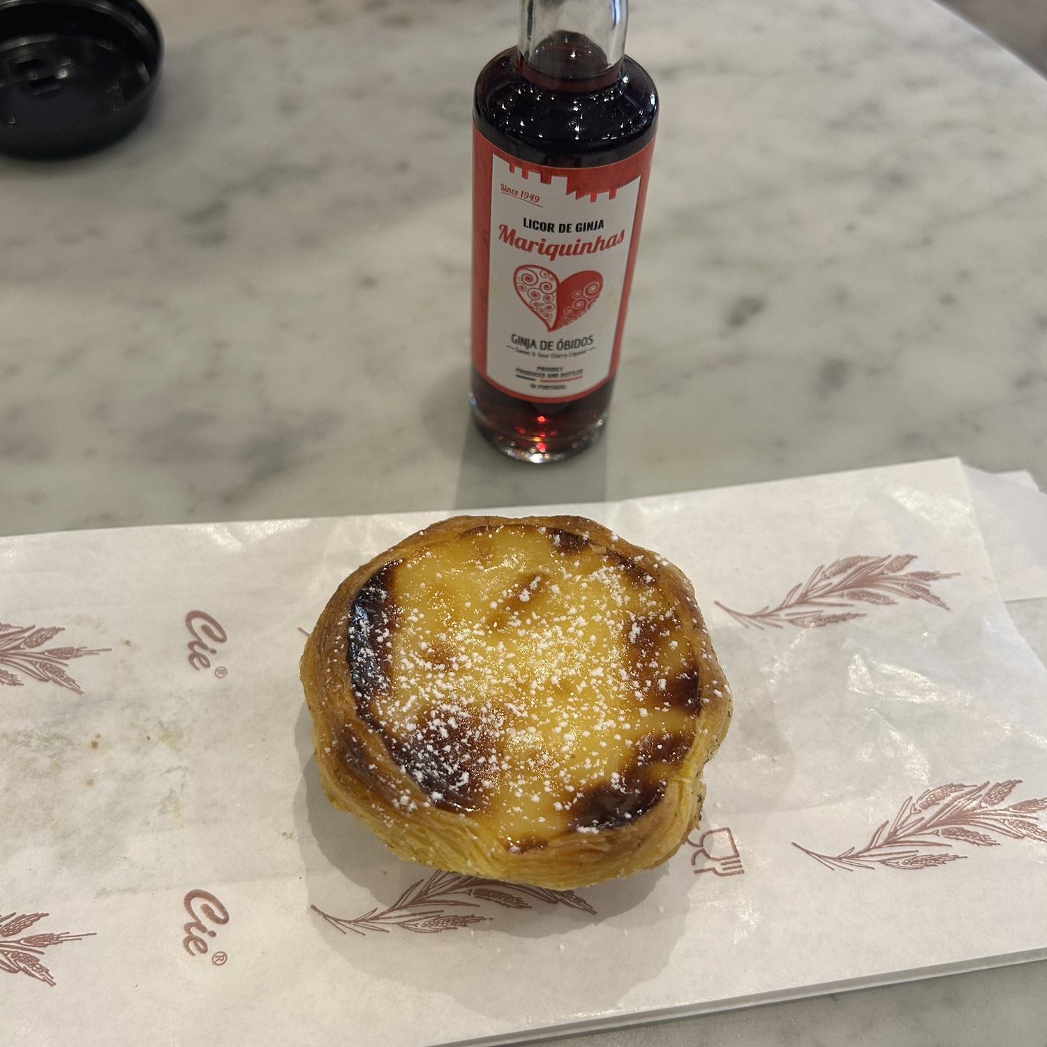 Enjoying a pastel de nata with the Portuguese cherry liquor called Ginja