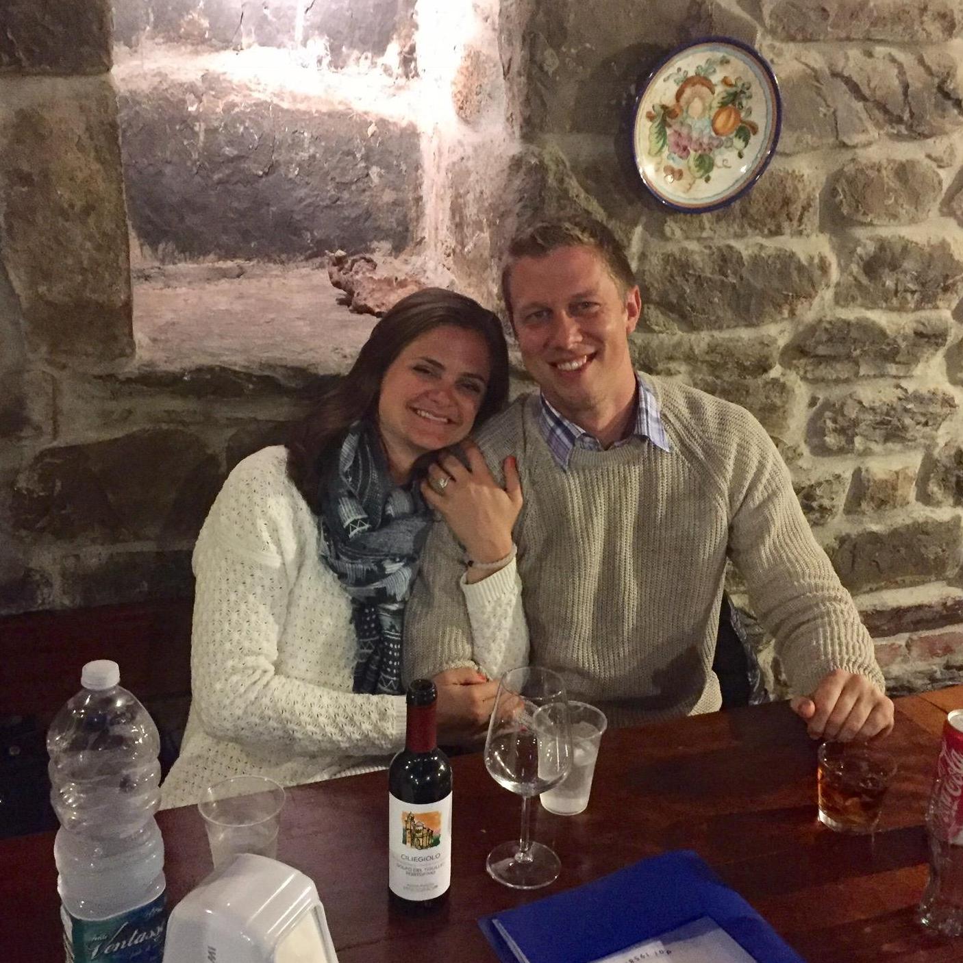 Melissa and Jess celebrating the evening after he popped the question in Manarola, Italy with red wine and live music.