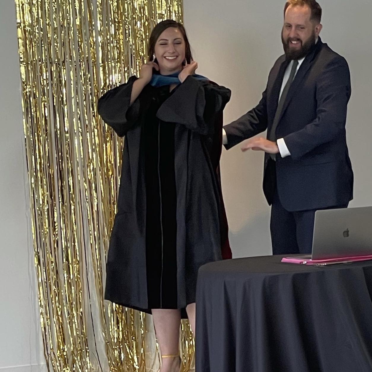 Stu donning Kayla’s doctoral hood..COVID graduation addition