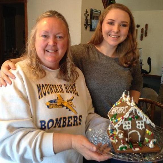 Kyle's Mom and Abbi making gingerbread houses during family Christmas.