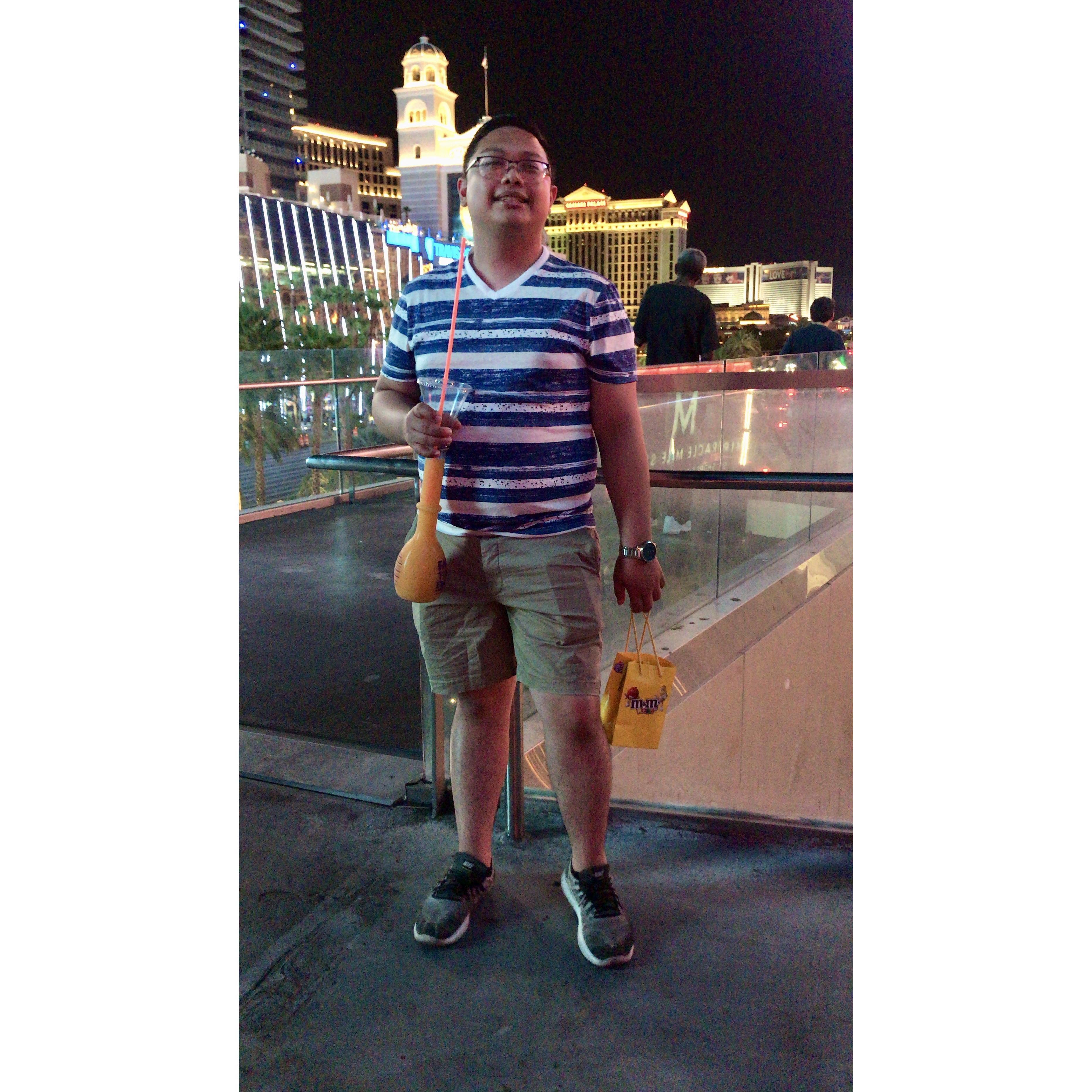 Jan enjoying the Vegas Strip view at night with a tall glass of Fat Tuesday