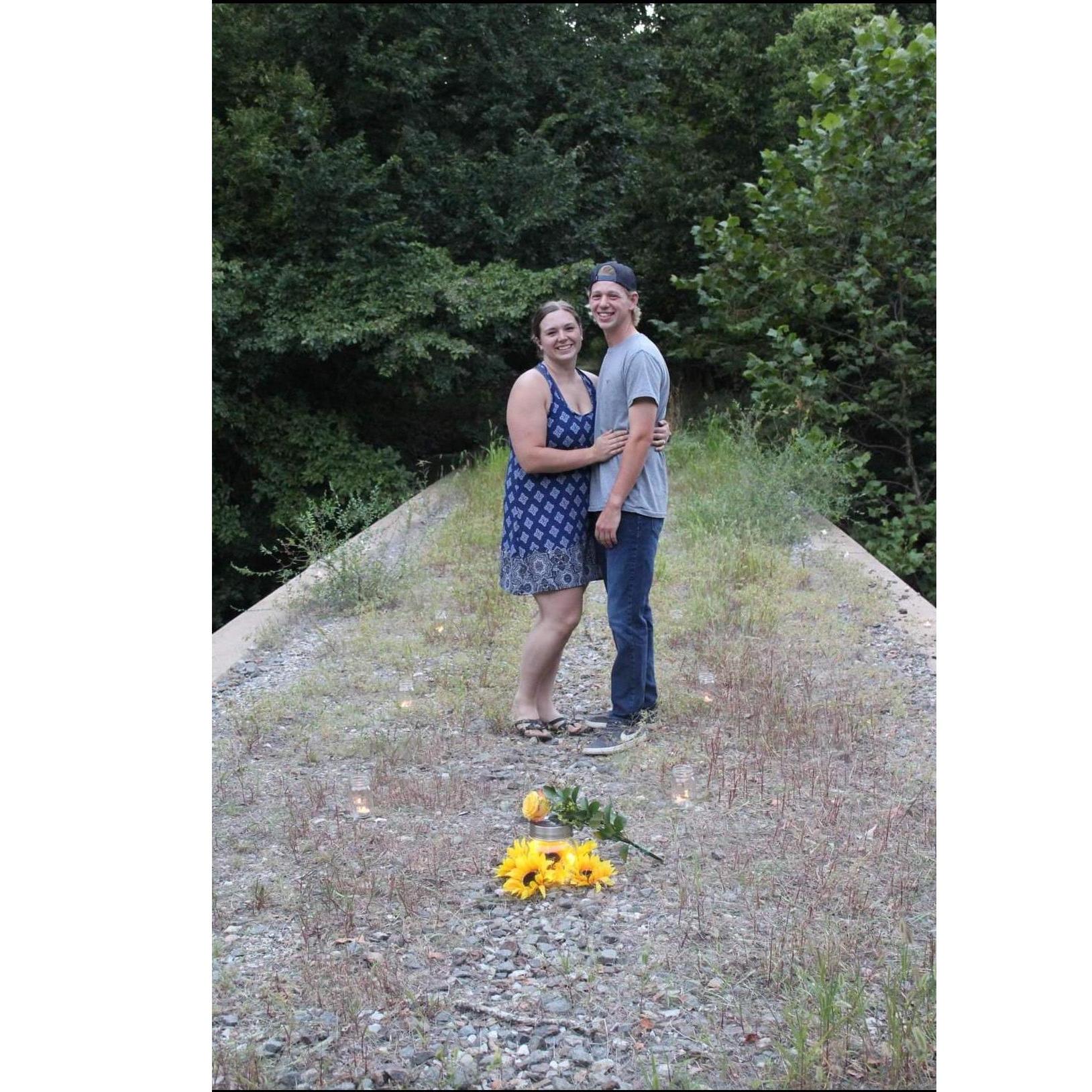 For the proposal, Michael secretly had his aunt Tiffy put roses, sunflower, and candles on the bridge where we took our first picture together while we were kayaking. Summer 2020