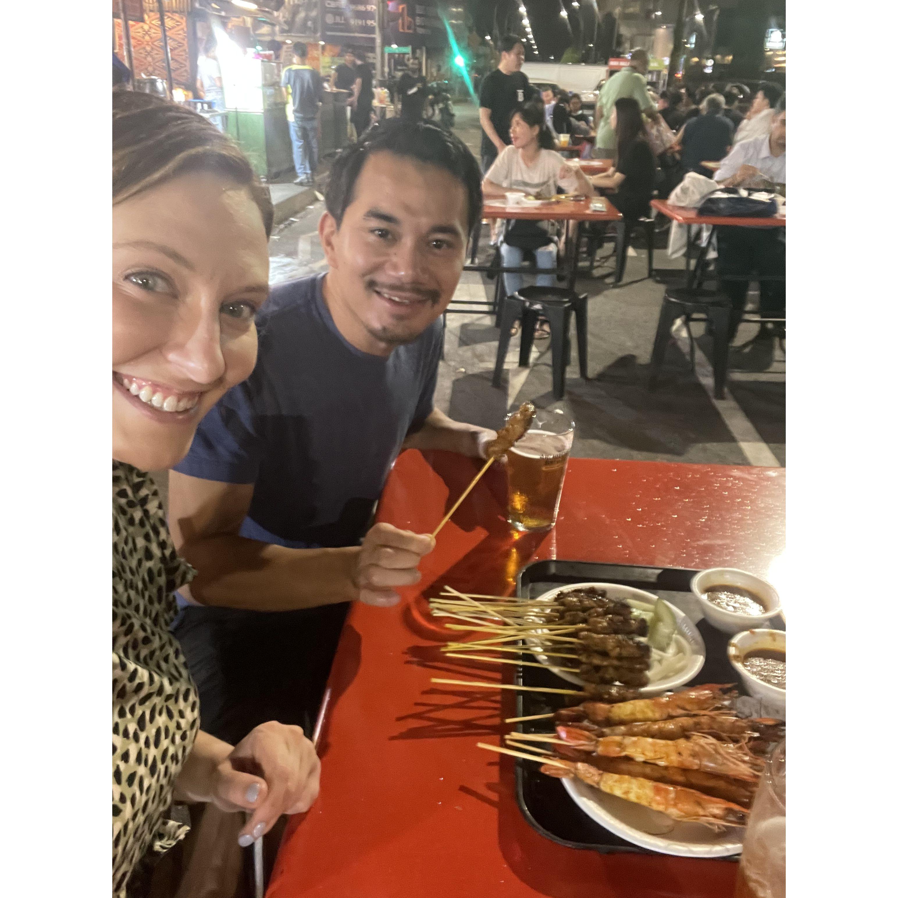 We love to travel and try new foods! This is in Singapore trying some yummy street food