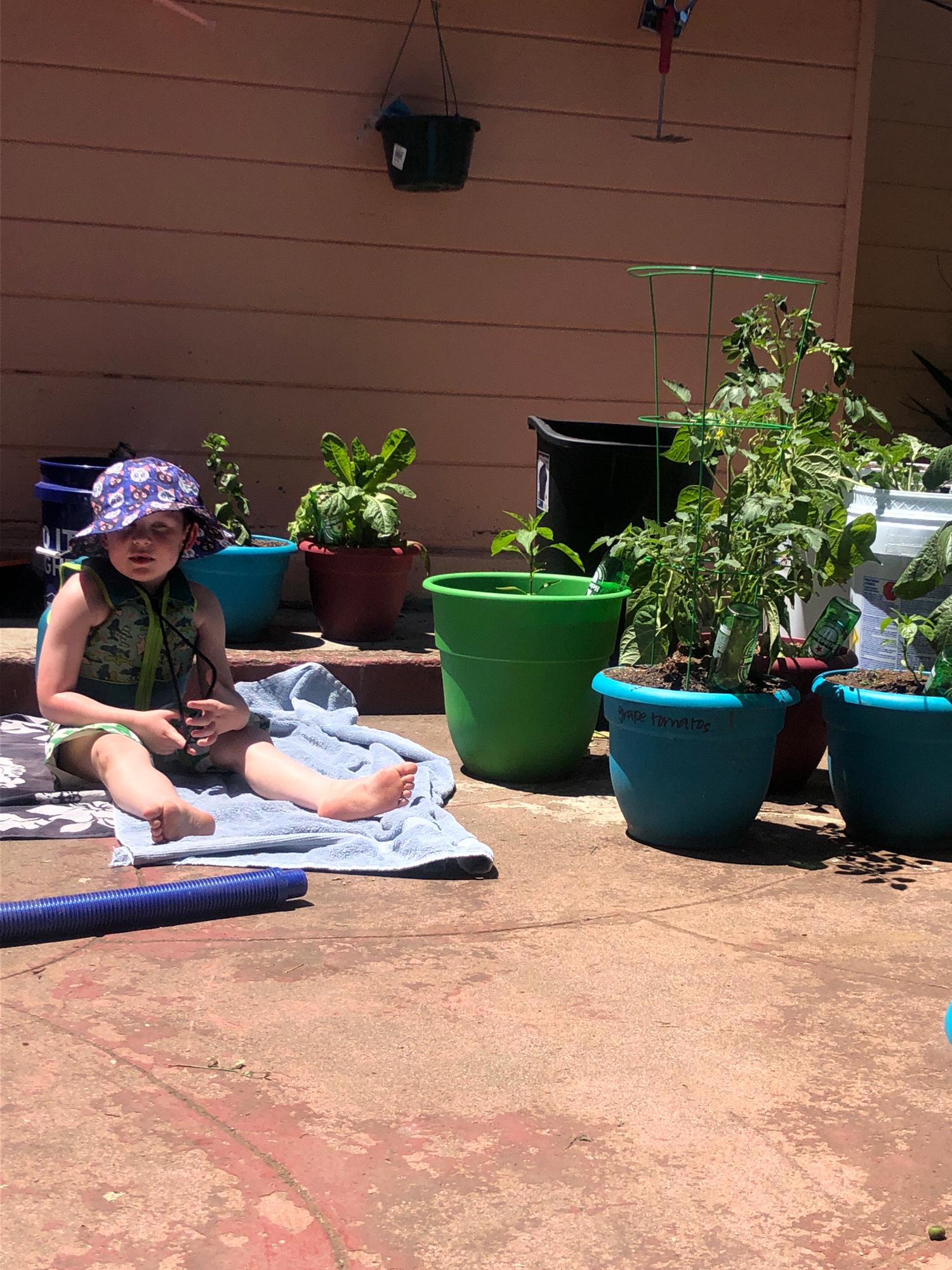 Our ring-bearer and godson chilling in our backyard with the plants