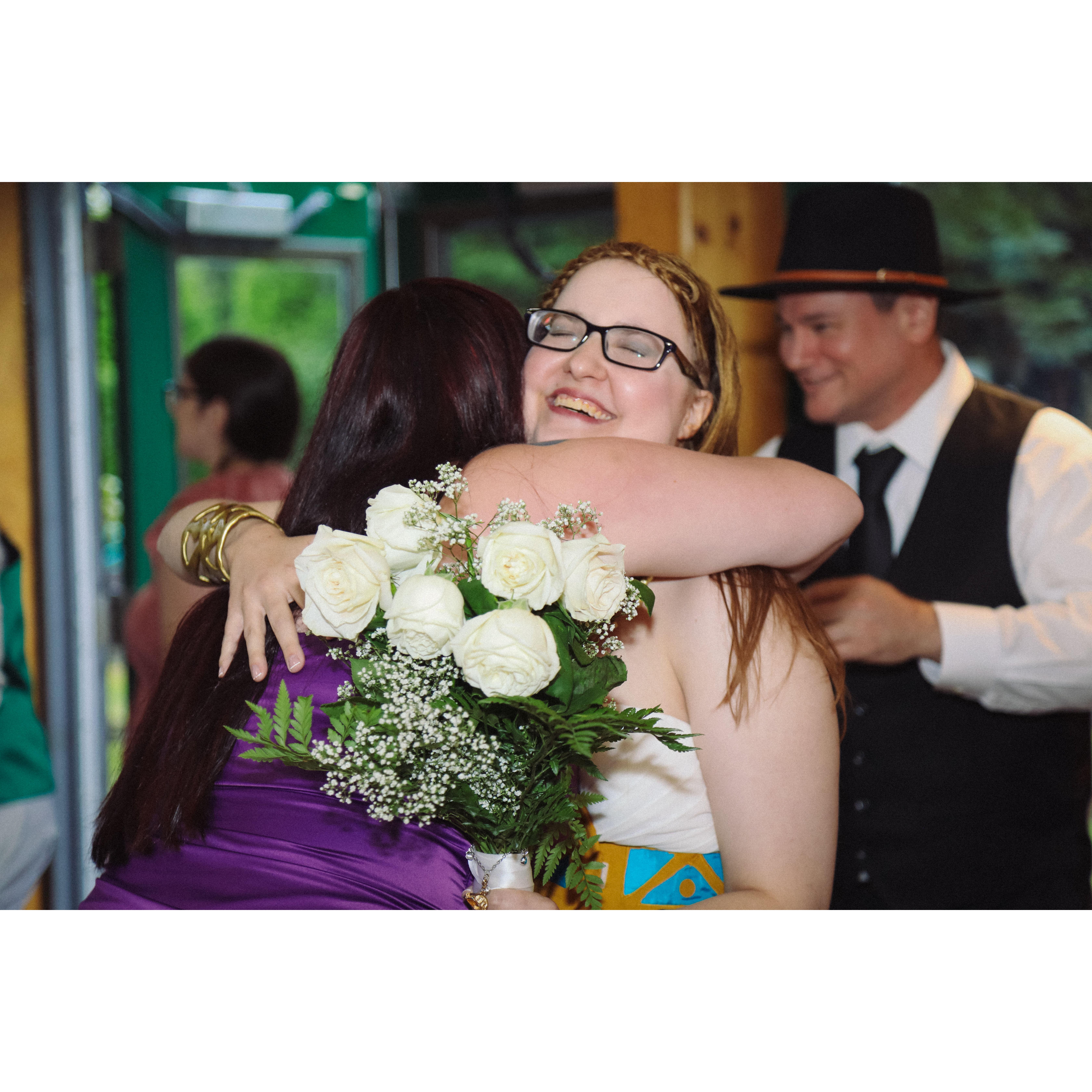 after the ceremony, Sara and Emily sharing a hug with John in the background