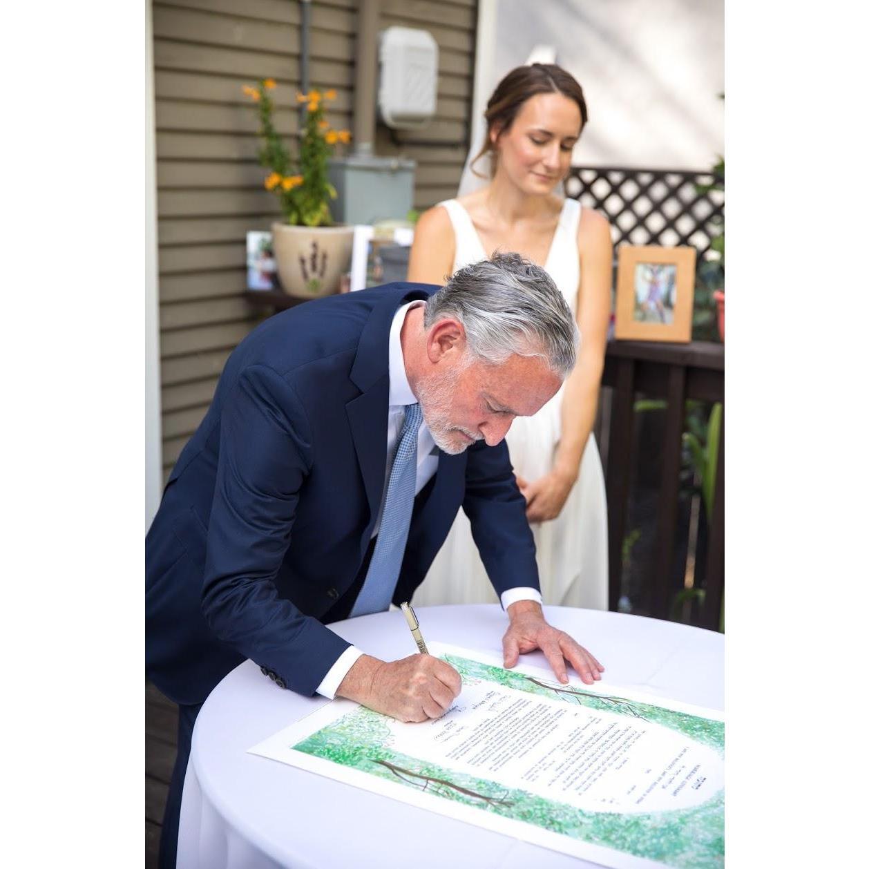 Rachel and her Uncle, Jeff, signing the Ketubah