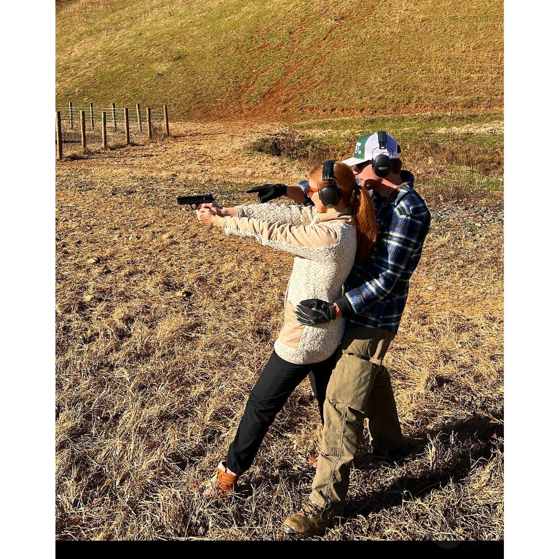 Lucas teaching Bella how to shoot a gun for the first time.