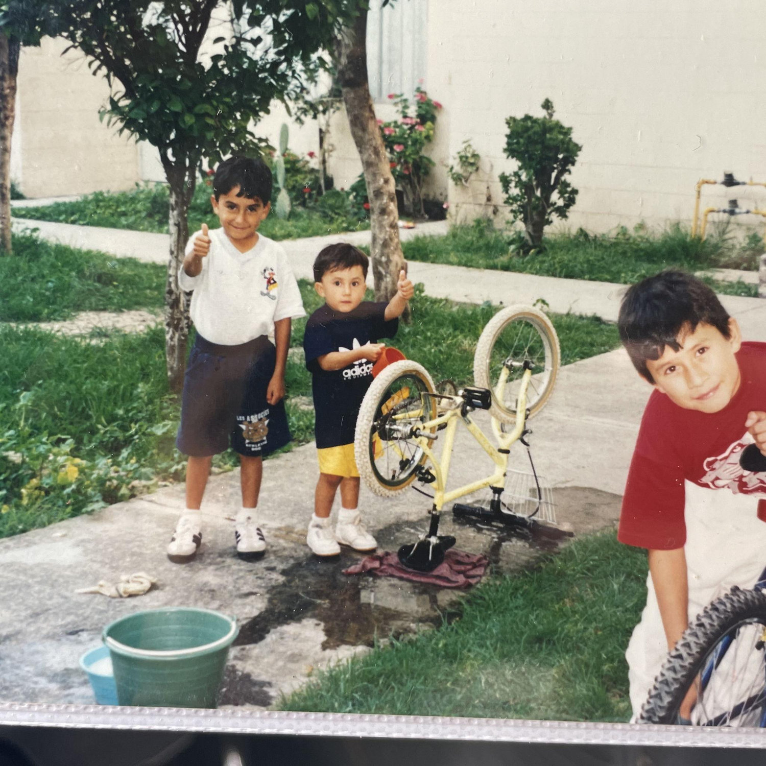 Jesus (middle) giving a thumbs up as a young lad.