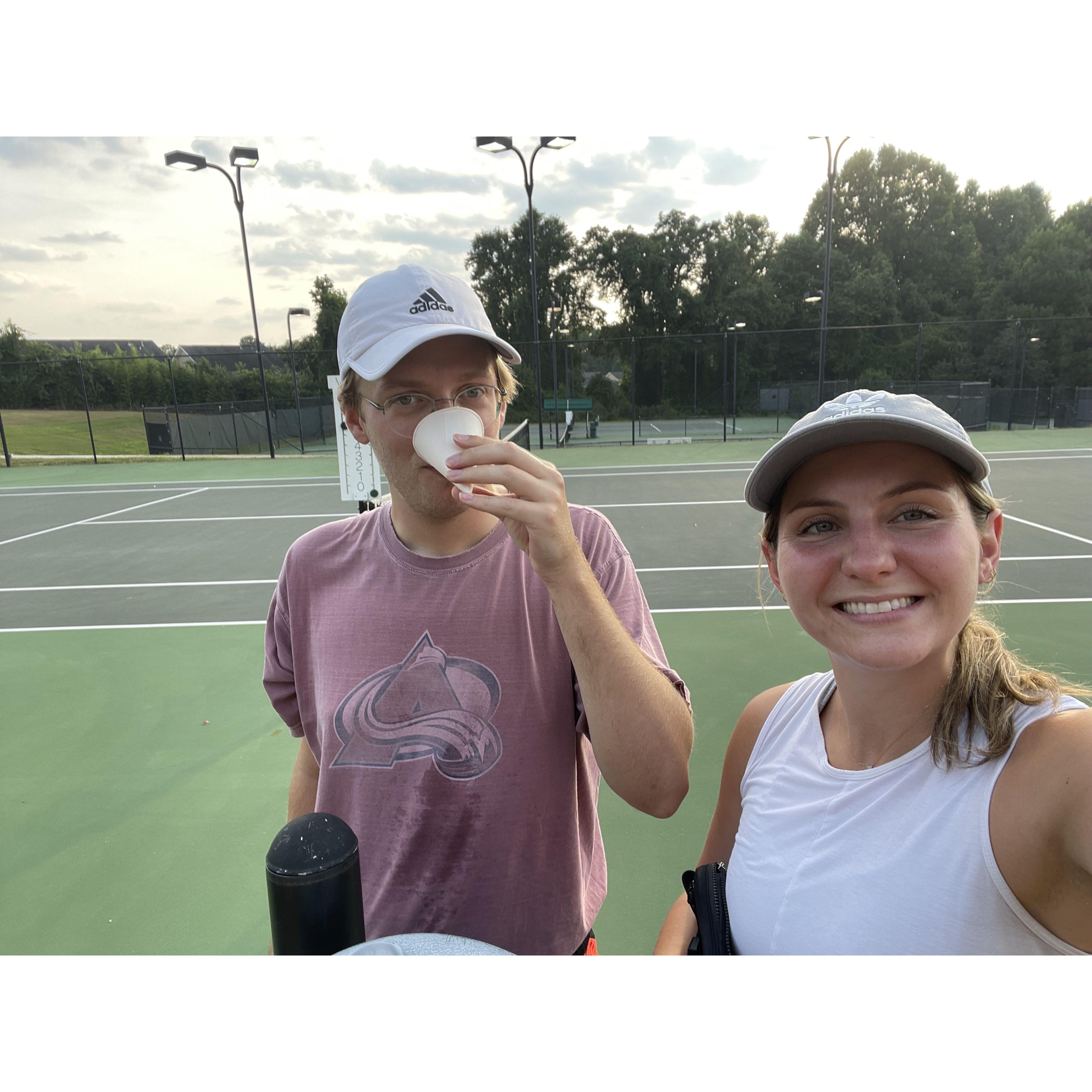 Zac teaching Marissa how to play tennis