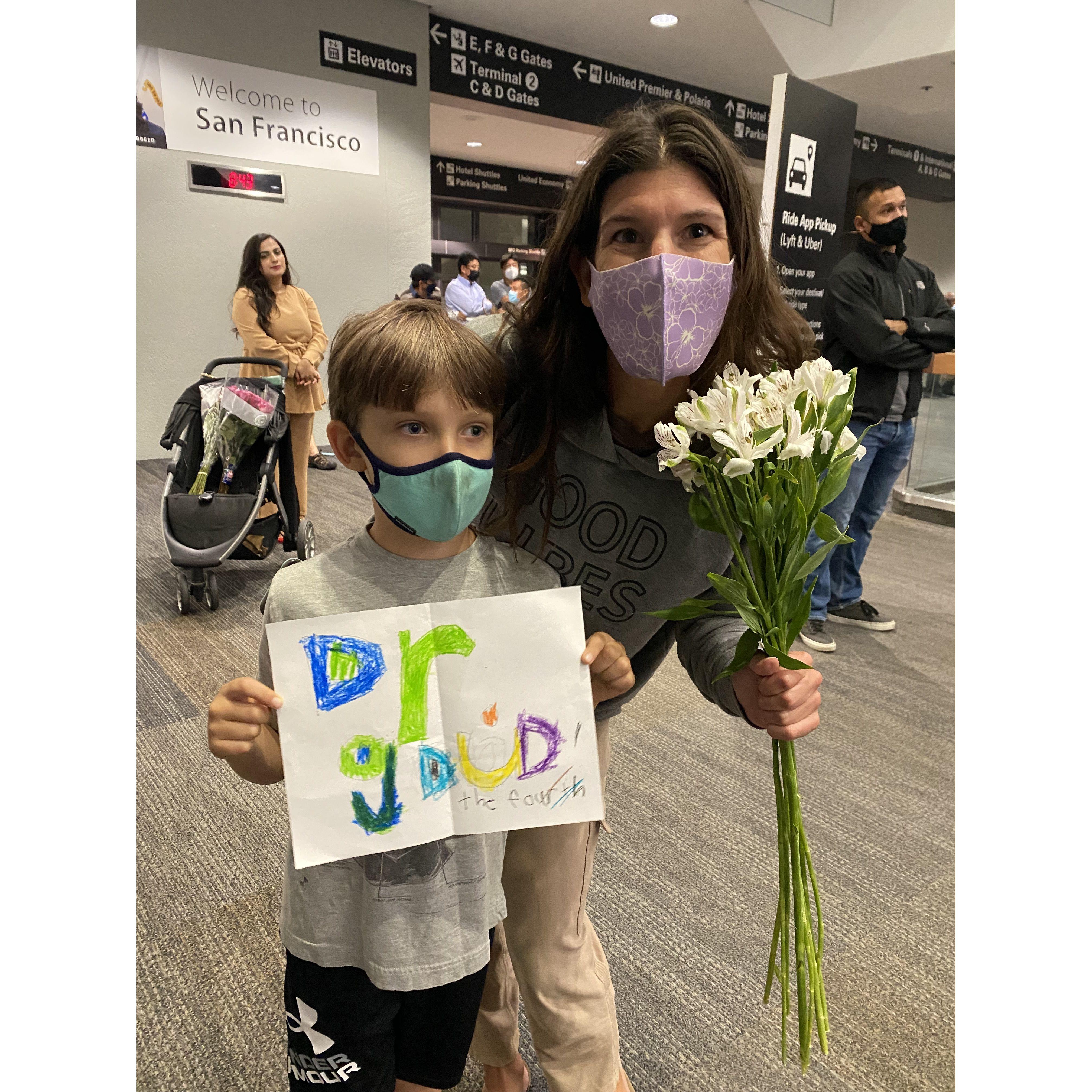 Ryan surprised Becca at the airport with a sign and flowers
