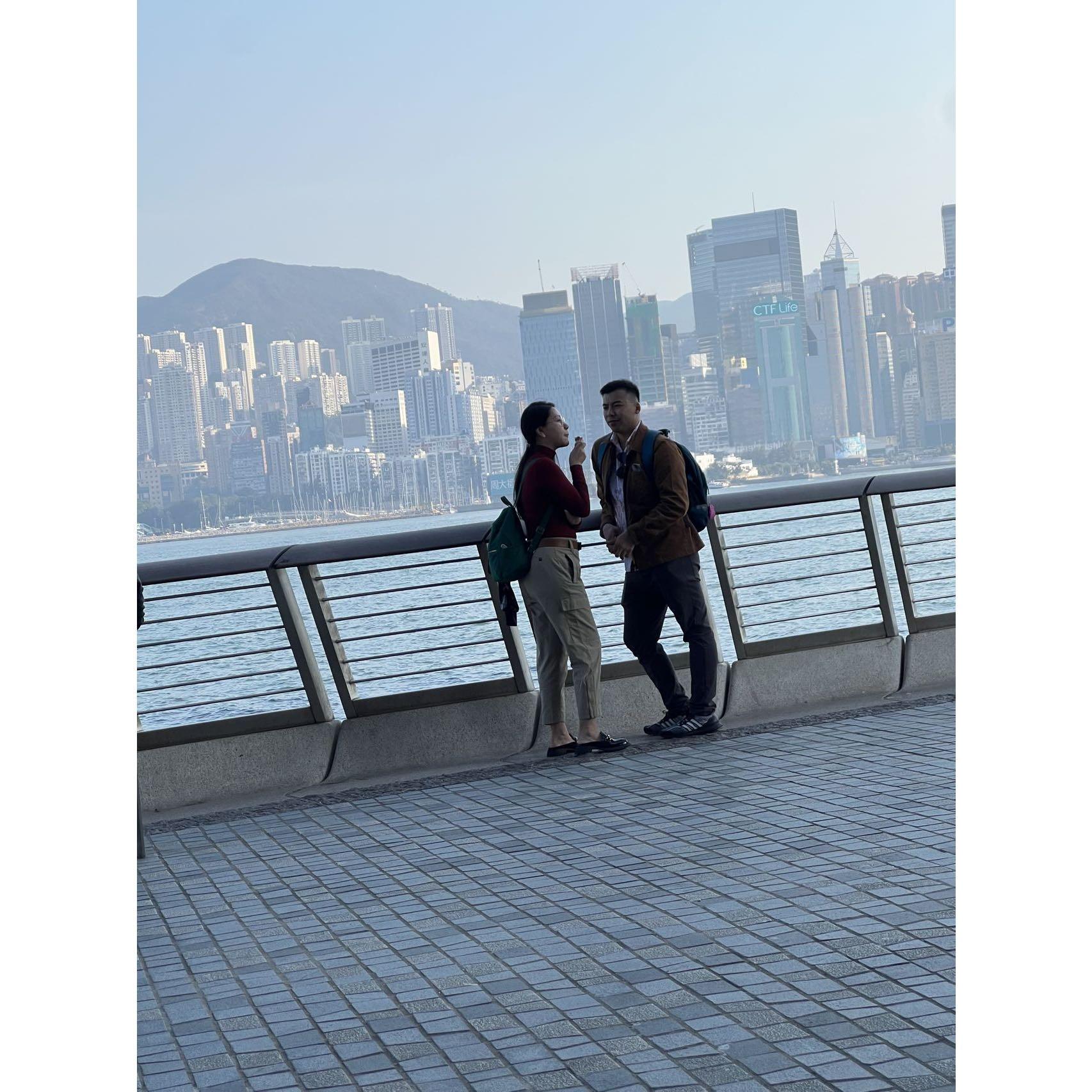 My tag-a-long cousin taking a admiring photo of us couple dating by HK the Victoria Habour