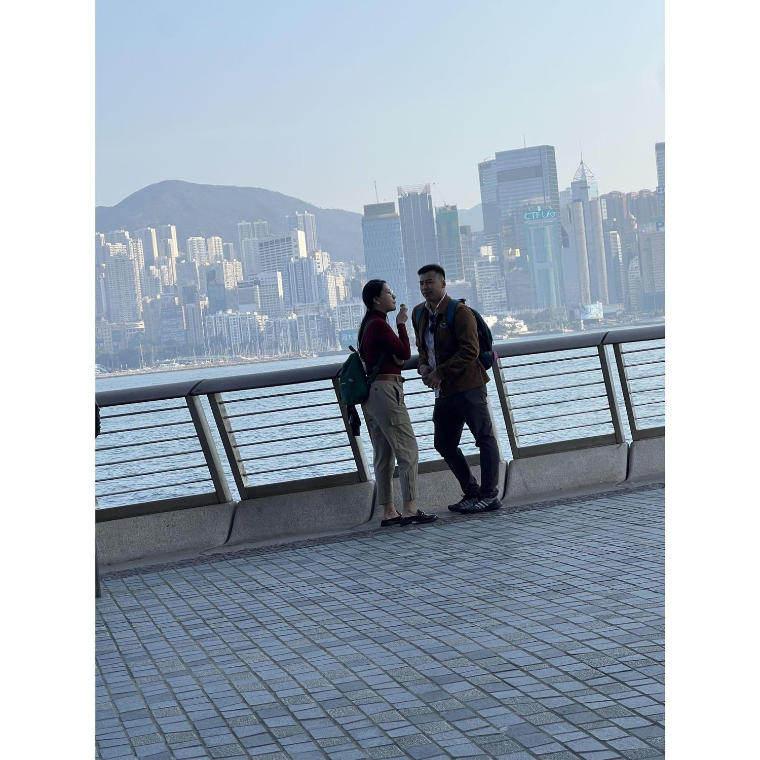 My tag-a-long cousin taking a admiring photo of us couple dating by HK the Victoria Habour