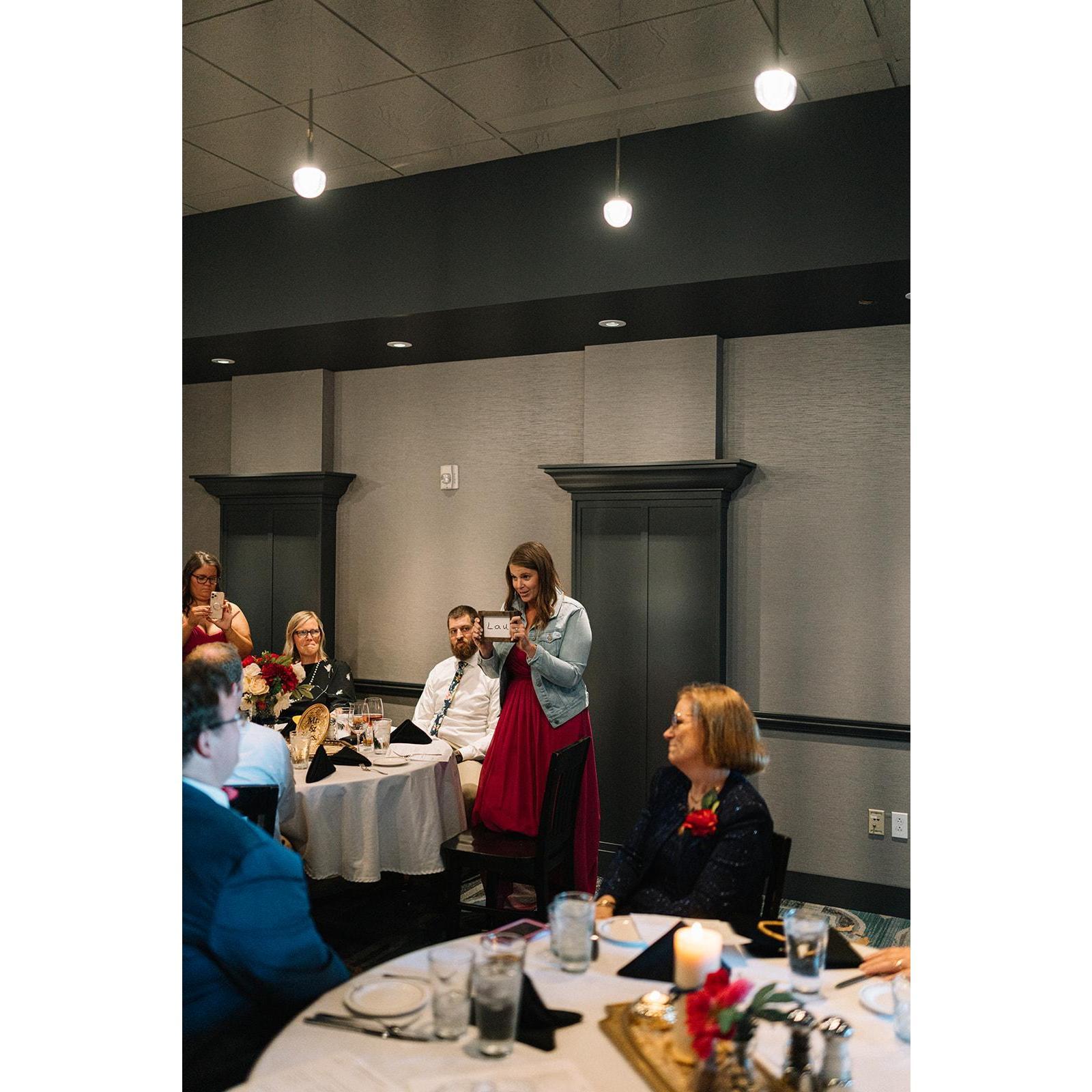Matron of Honor, Katie, explaining the significance of the "Lau" plaque.  Mother of the Bride's handwriting of the couple's last name!