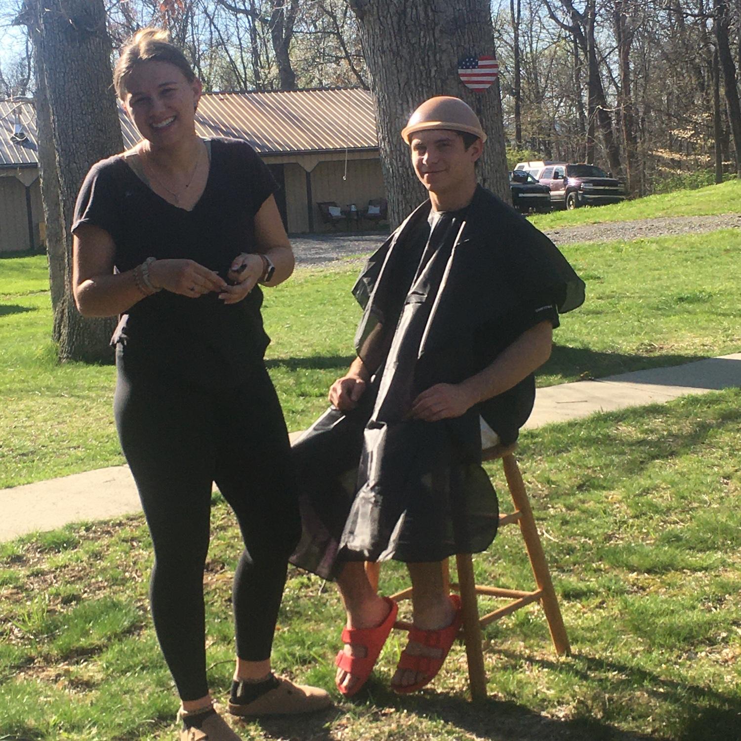 Thadd (groomsman) gets a bowlcut from Elayna (bridesmaid.)