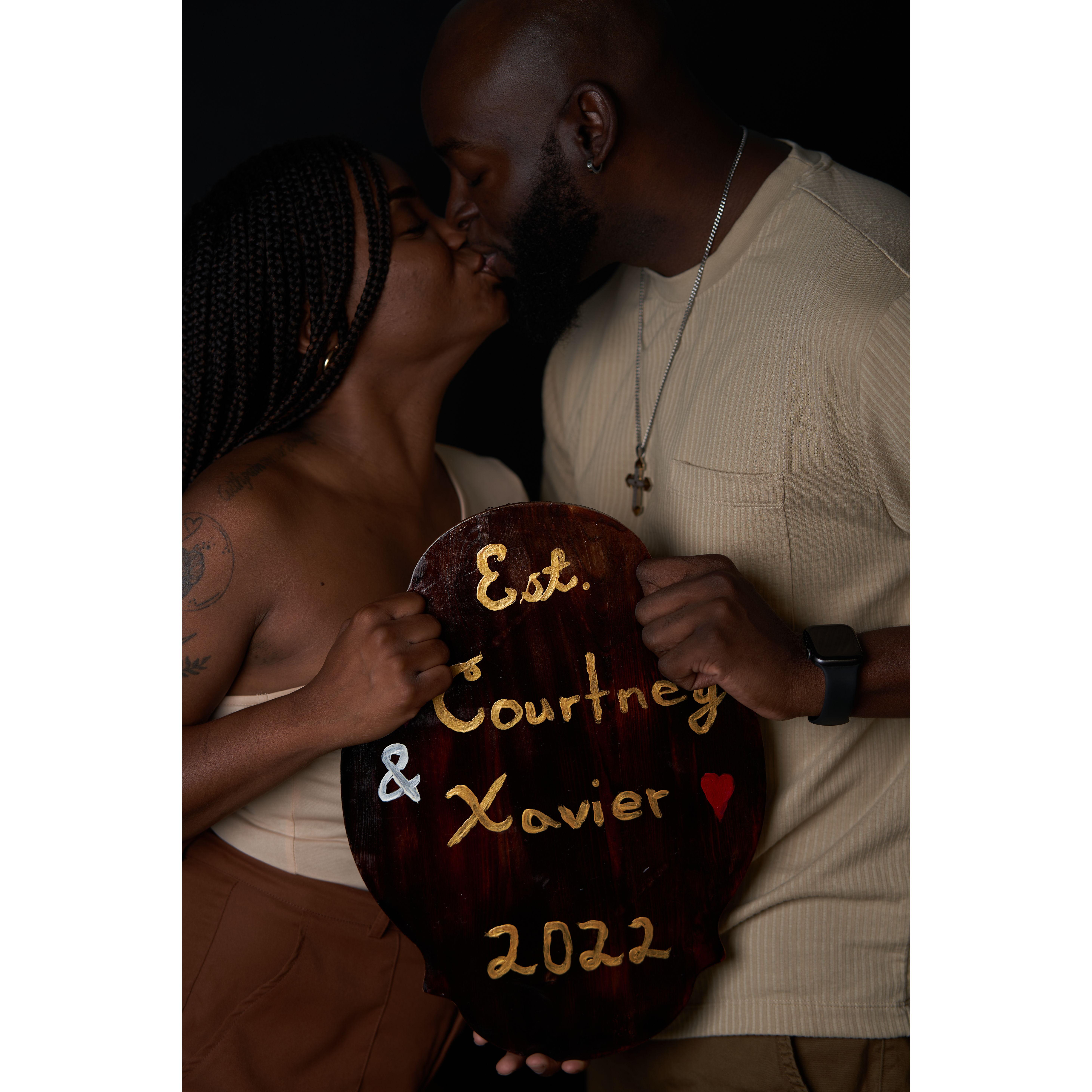 This is a picture we took as a part of a couples portrait shoot and the board is painted by Xavier. Each year, we scratch a tally mark onto the board.