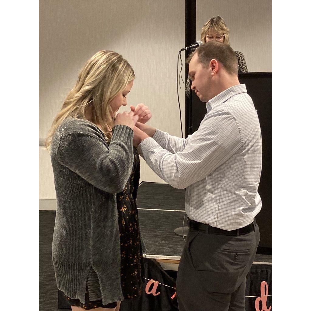 Matt pinning Aubrey after completing nursing school in December 2021