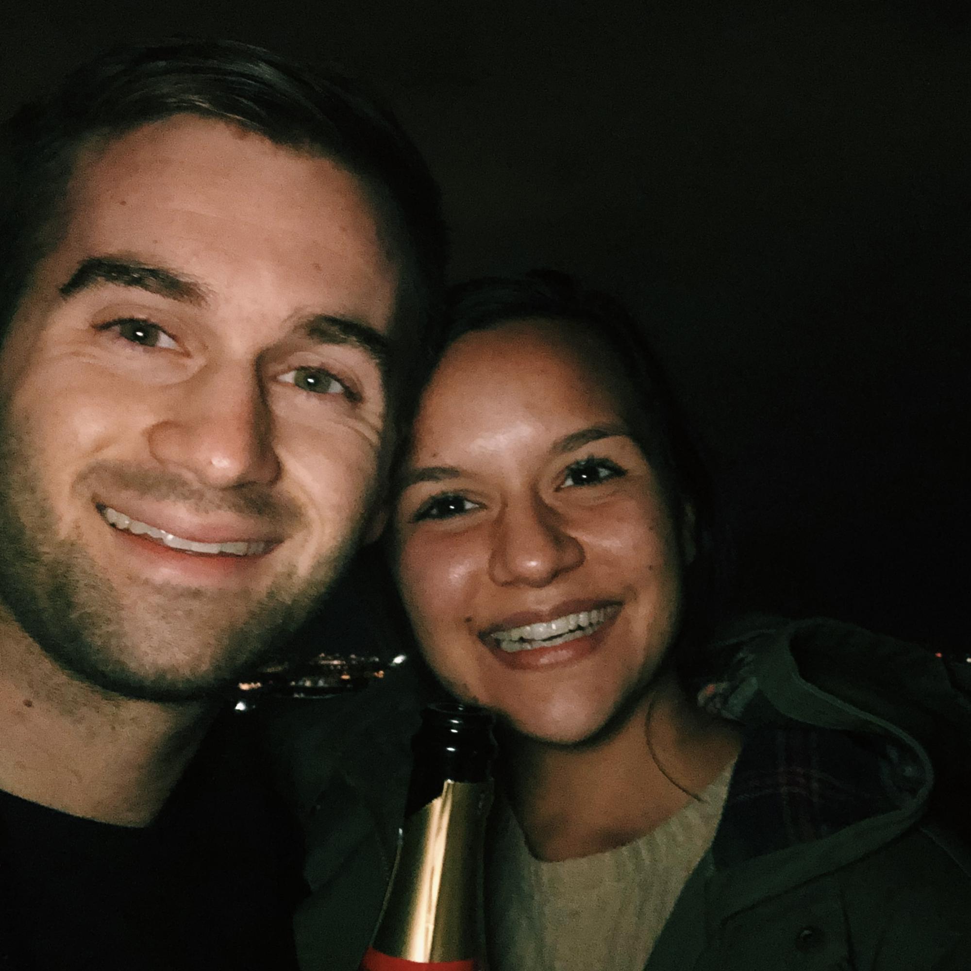 Steph and JD enjoying a champagne toast on the roof top of their first DC apartment
