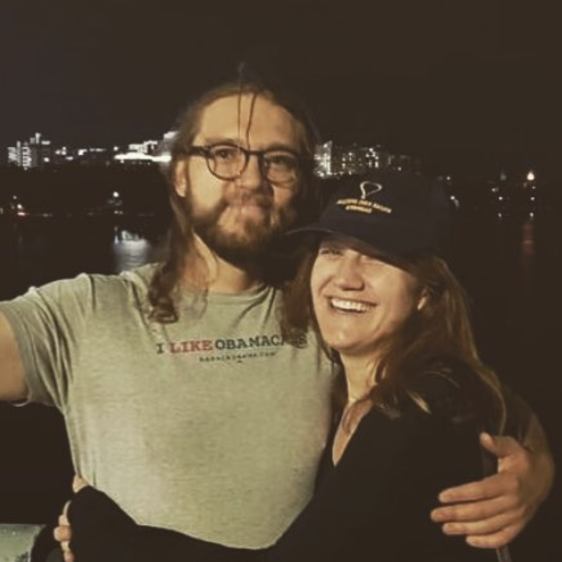 Boston evening after a red sox game. Keldin's arm is extended taking a simultaneous selfie