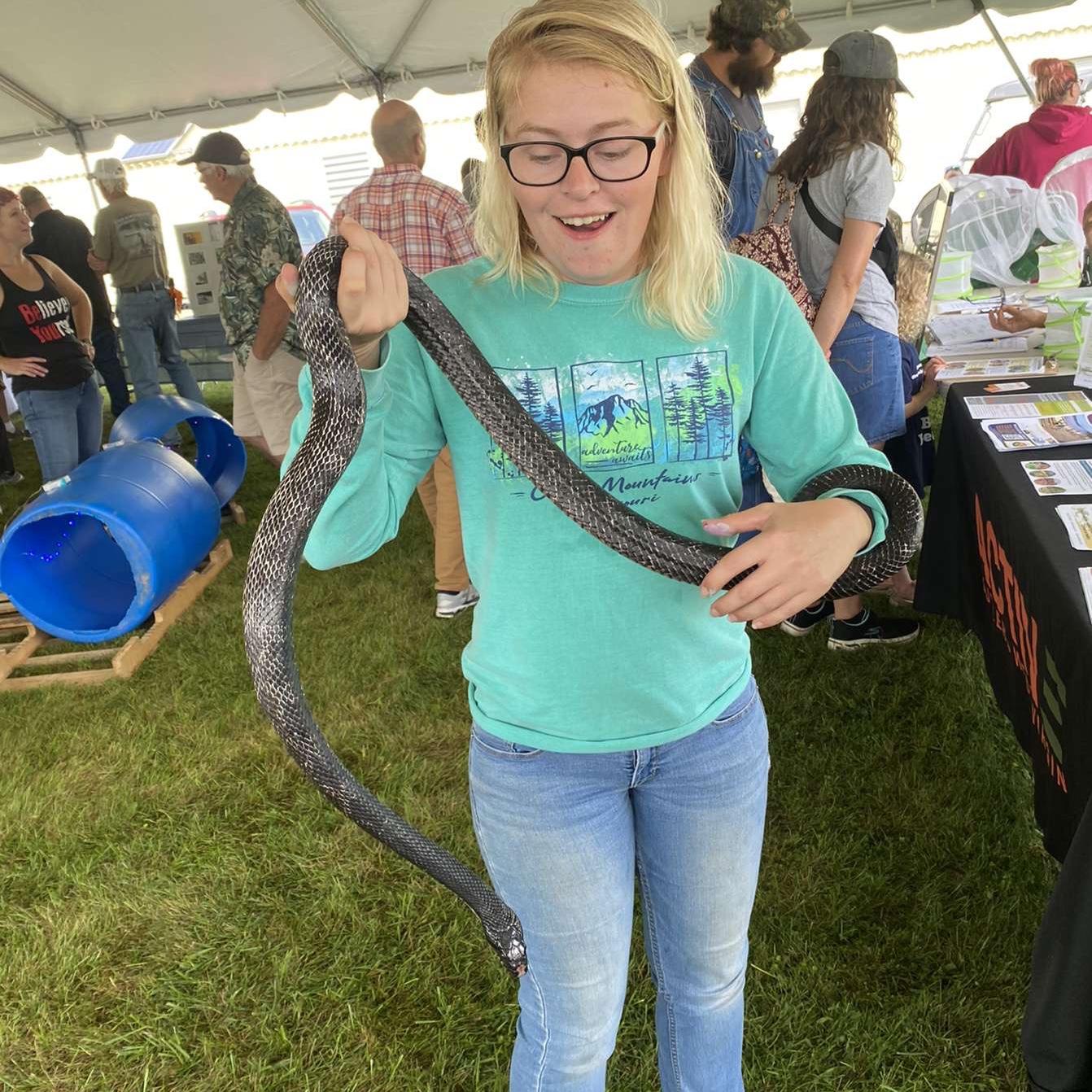 Jess holding a snake after Gregory dared her to at a festival in White Sulphur, WV.