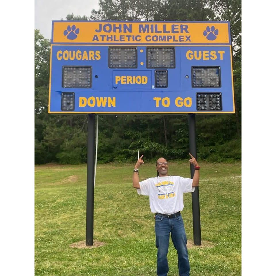 John got the football field at the school he teaches at named after him.