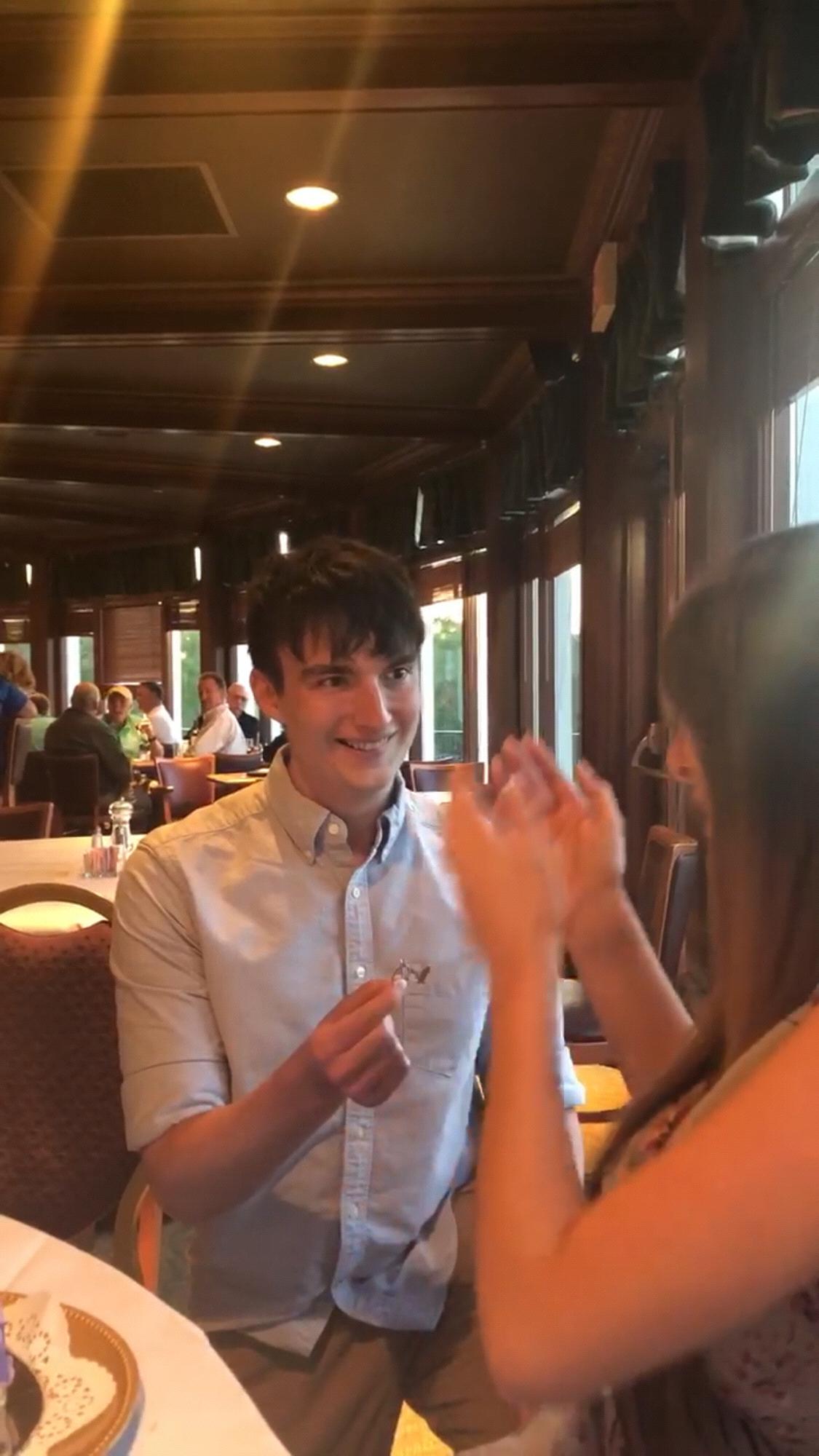 Still shot from the proposal video; Alex down on one knee ❤️