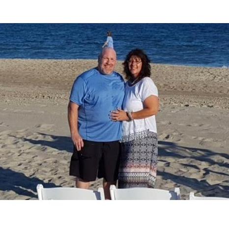 At his son's wedding. Notice the person walking on the beach in the background? Looks like she's right on top of his head!