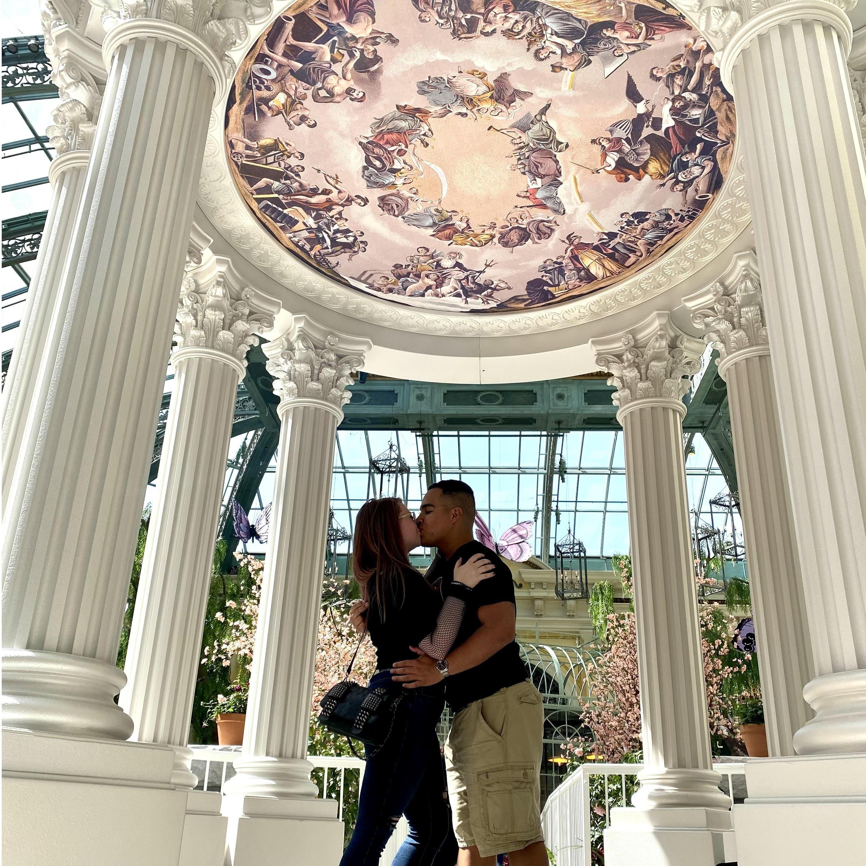 A smooch underneath the decorations at the Bellagio's botanical gardens.
Un beso debajo de las decoraciones en los jardines botánicos del Bellagio.