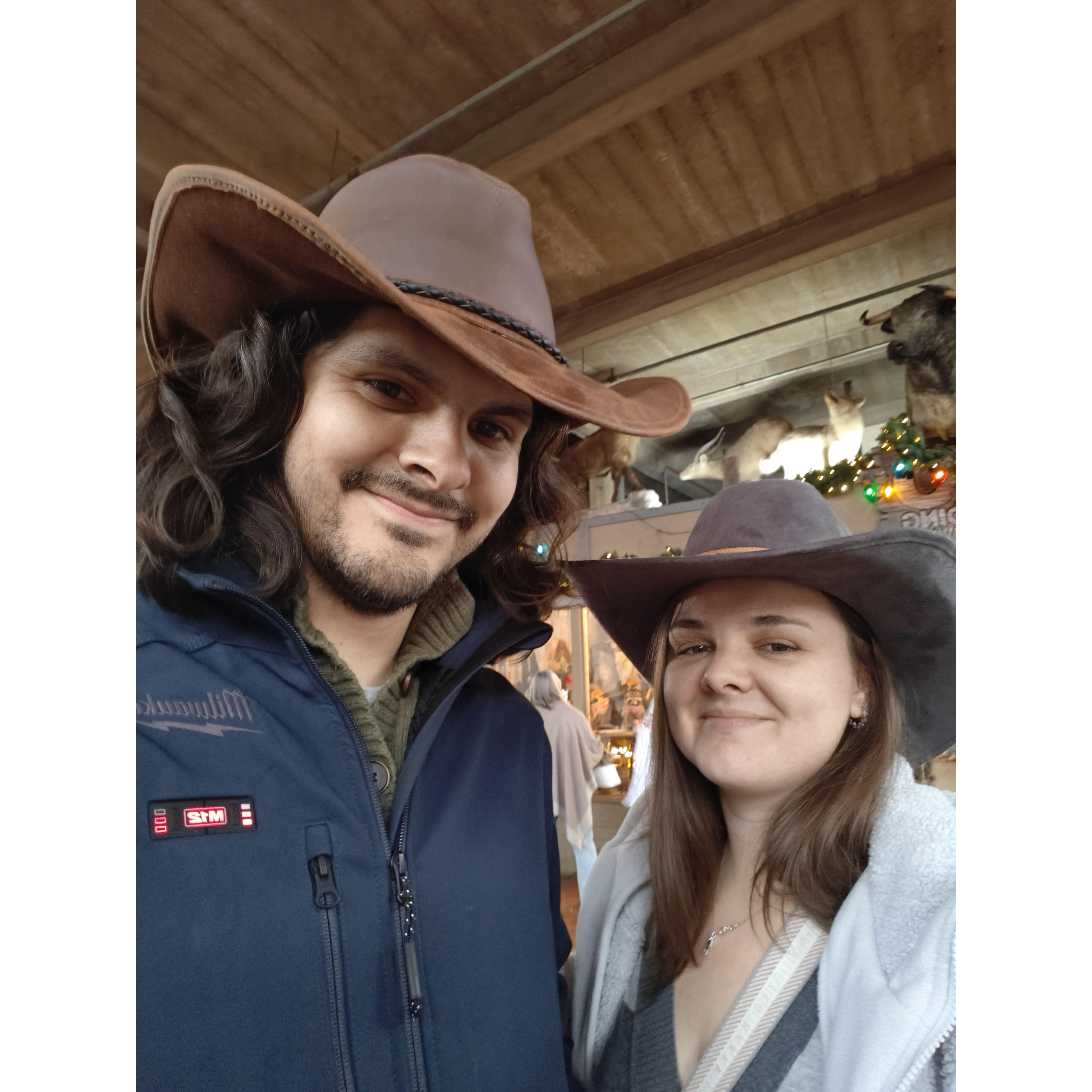Yeehaw! Newly engaged, the couple was in Fort Worth, Texas at the Stockyards in December 2024. This picture was taken right after purchasing the swanky cowboy hats they still proudly wear today.