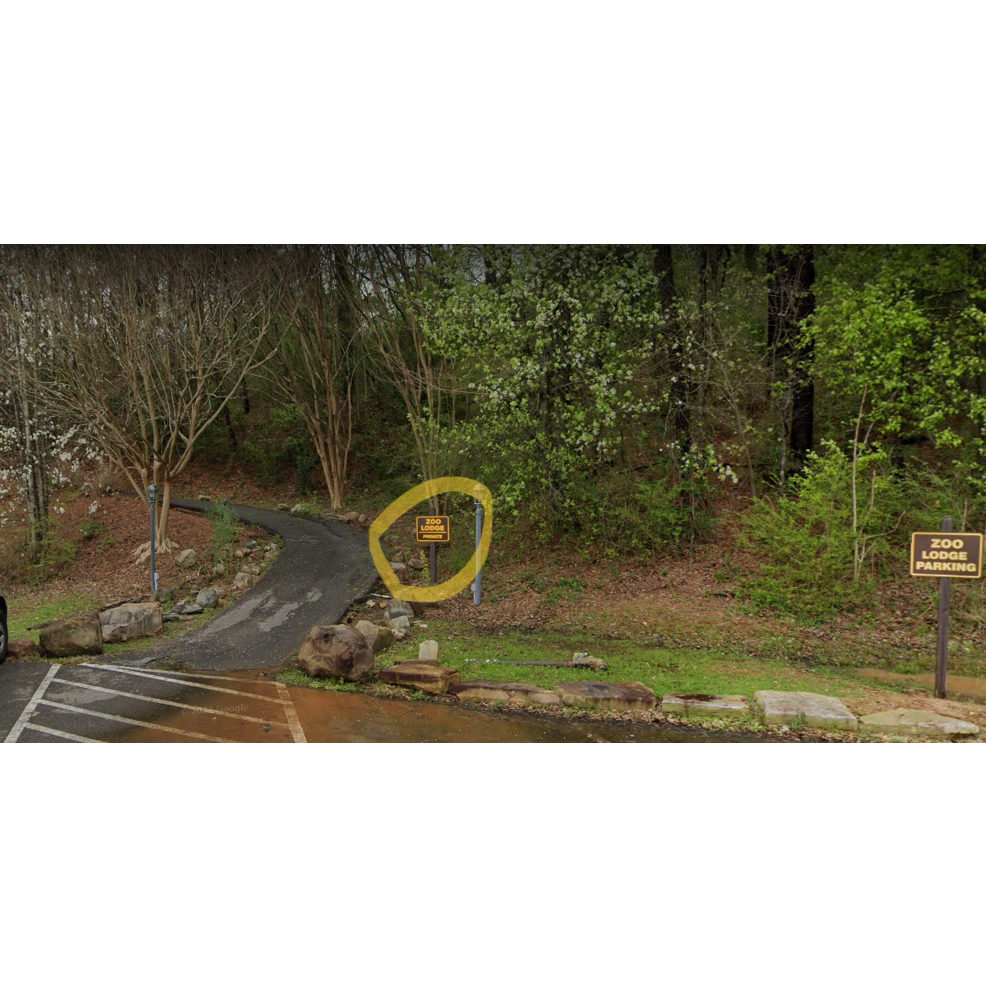 The view directly outside of the path that leads to the Lodge, sign leading to the trail circled in yellow. Convenient parking is available to the side.