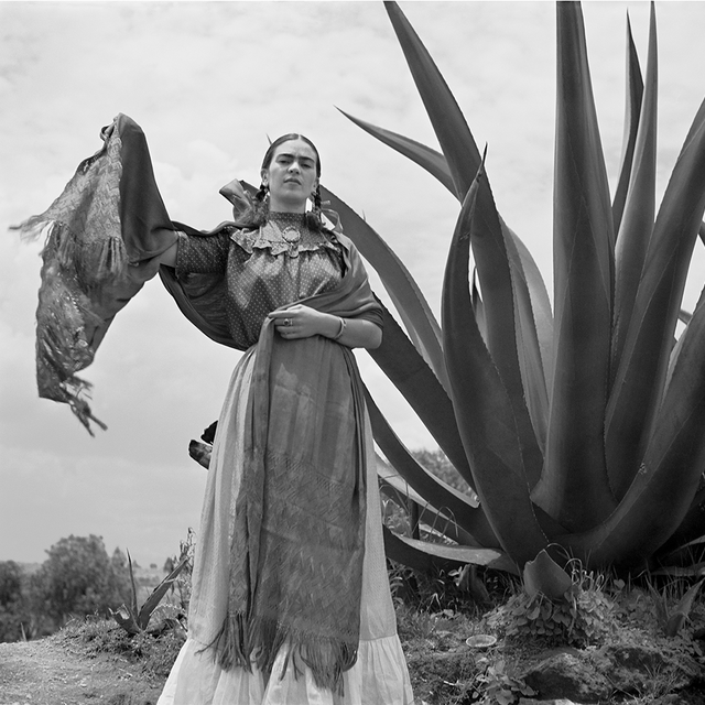 Frida Kahlo standing next to an agave plant