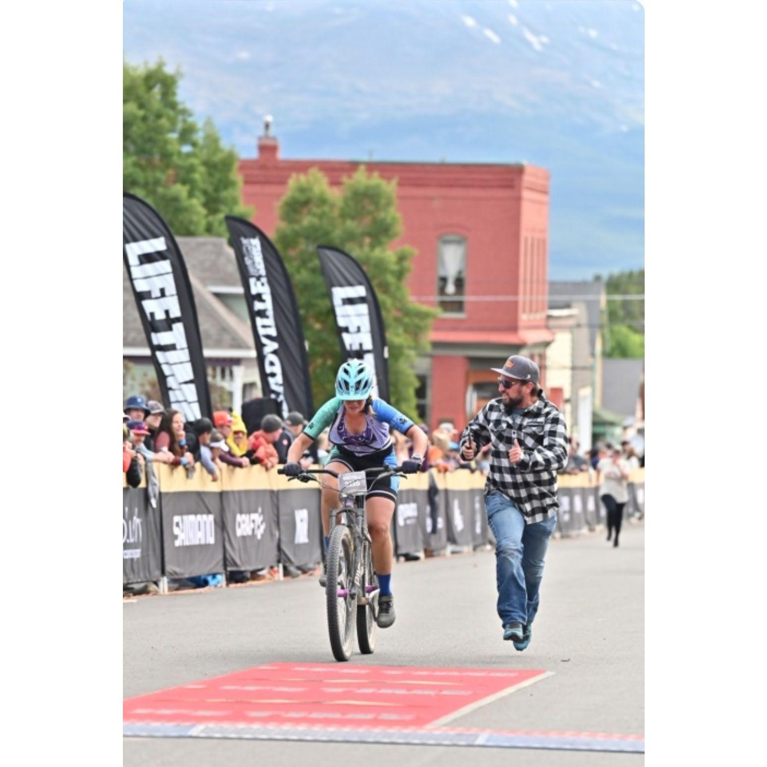 Bradey running across the finish line with Erin at the Leadville Mountain Bike Race!