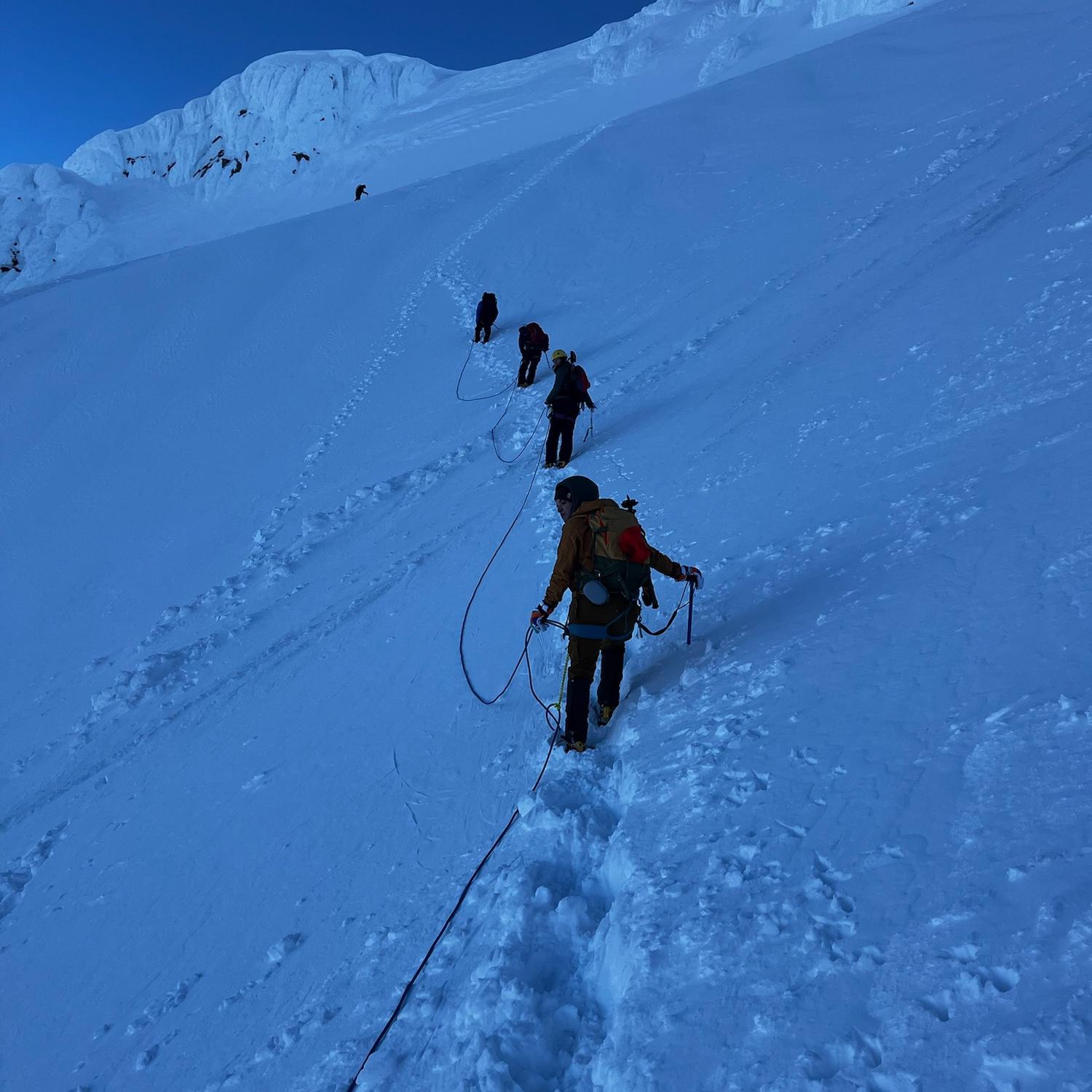 On ropes and traversing up from Hogback, everyone steps carefully with axes in hand and ready to self-arrest in the event of an unexpected slip.