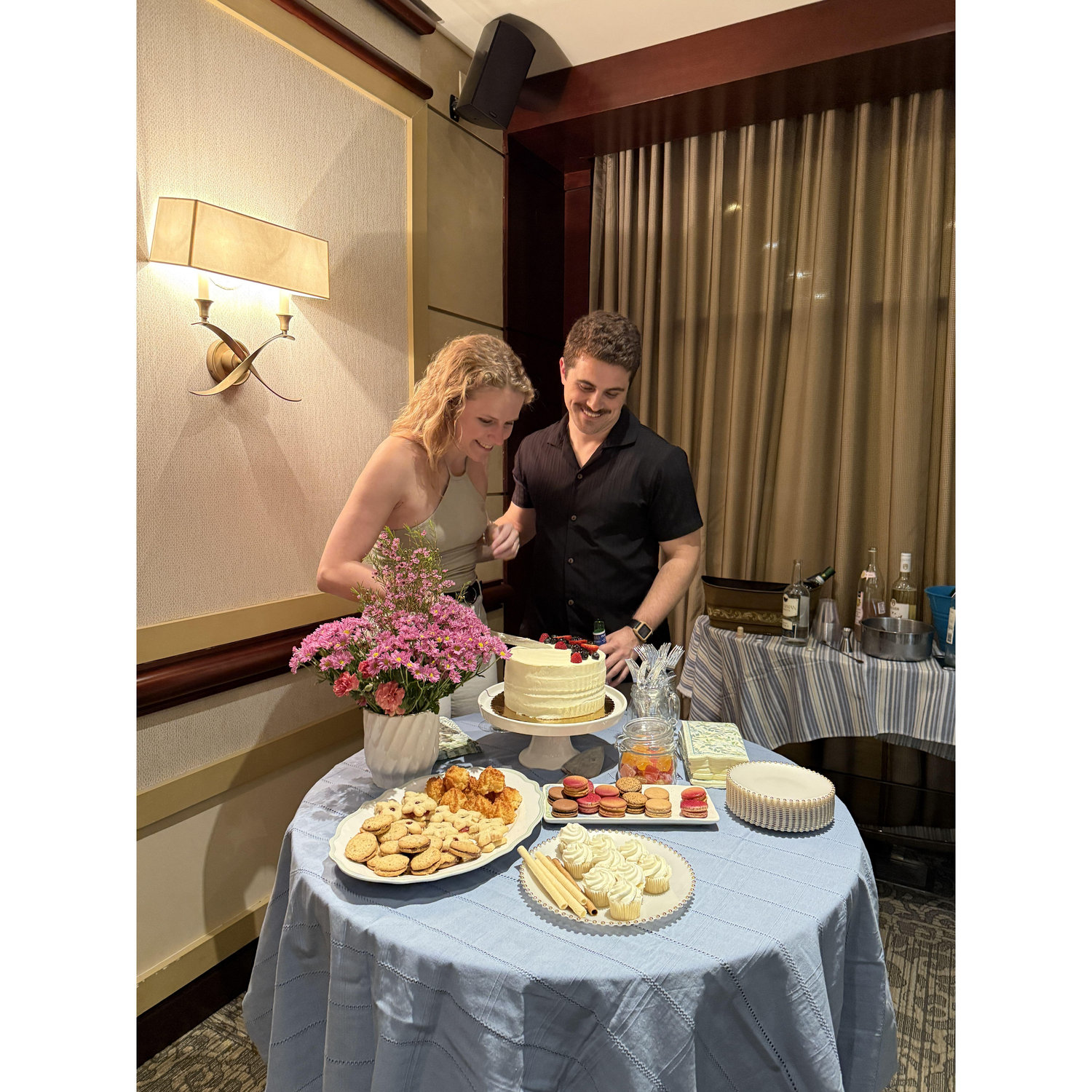 Cutting the cake at our "one year out from getting married" party in April 2025.