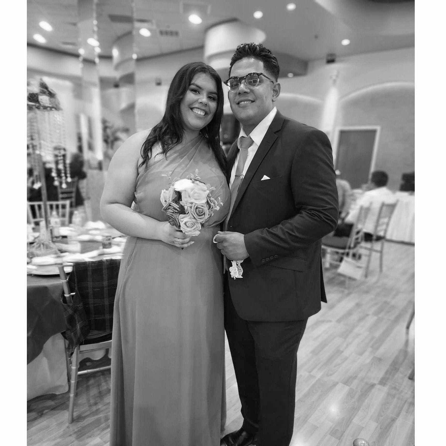 Rafael observa con emoción a Biancely atrapar el ramo en la boda de su amiga, mientras su anillo espera en casa, listo para sellar su historia de amor.