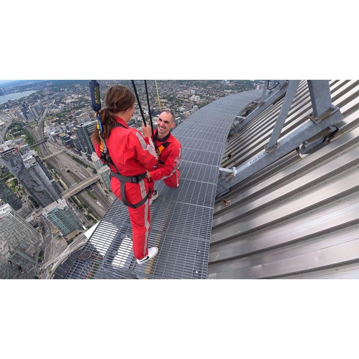 Mike surprised Hannah with "Will you marry me?" on top of the CN Tower in Toronto, Canada.