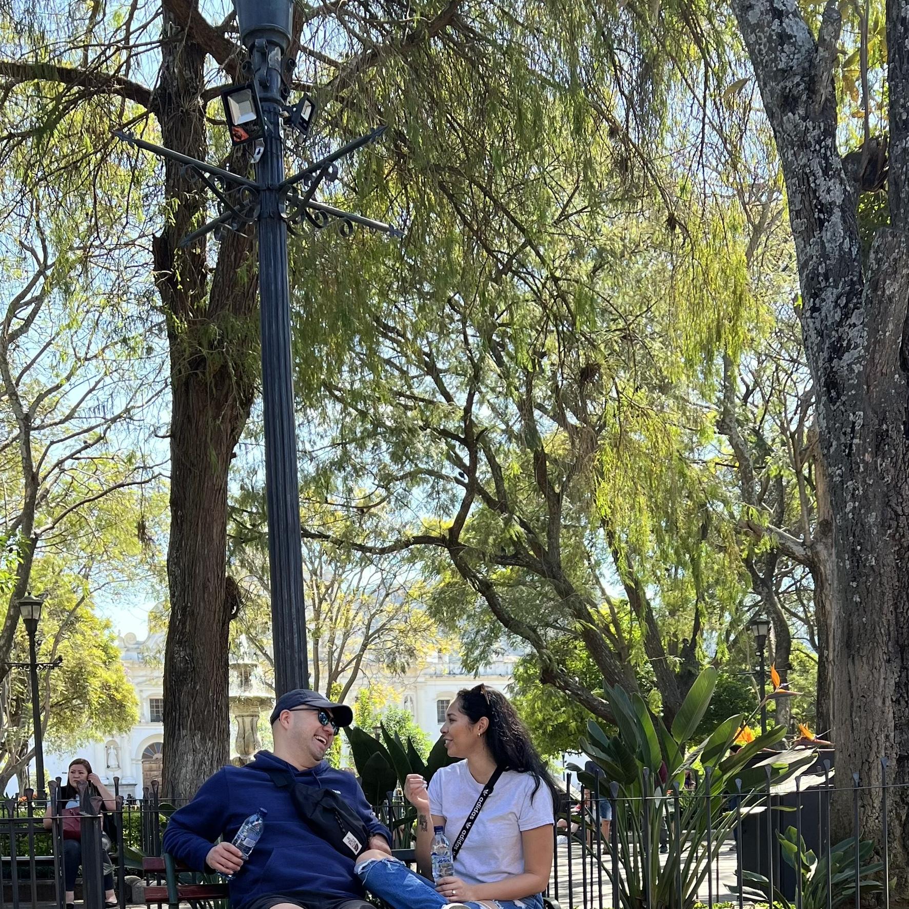 Sharing good laughs here. Sit down and take a load off on the park bench in the town square, Antigua's Central Park.