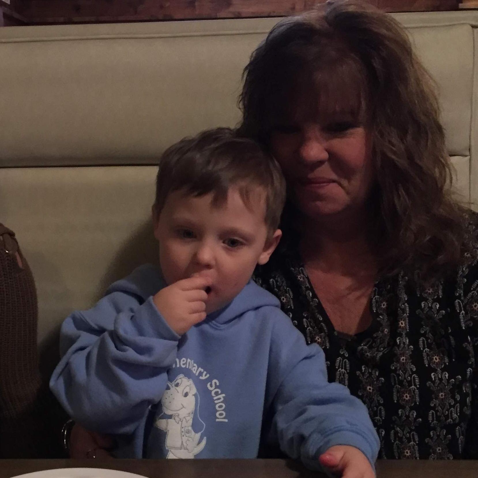 Paxton and Grandma Jeanette snuggled up in a booth after bowling💚