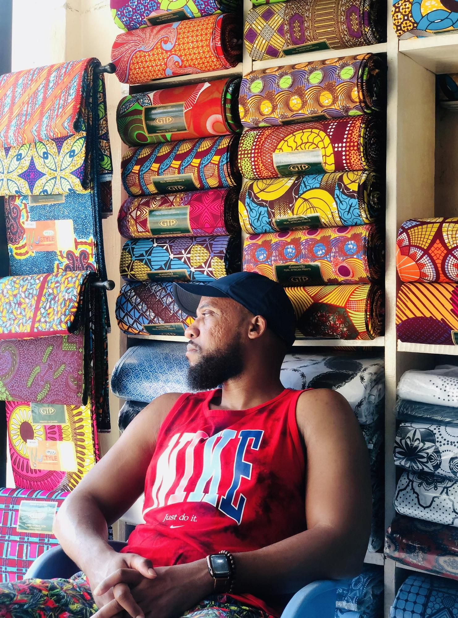 Carrington patiently waiting for me while I'm buying fabric in Makola Market in Ghana