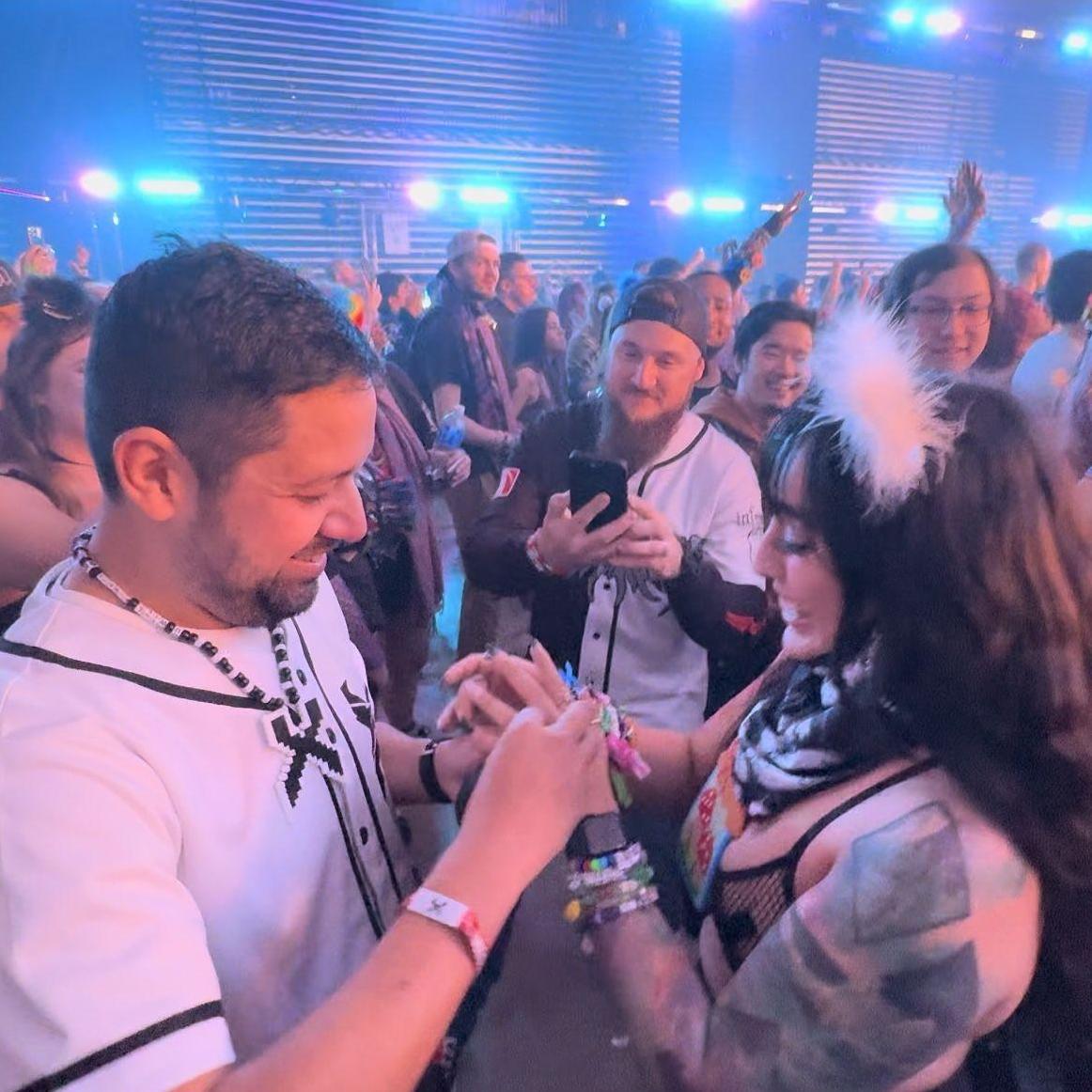 What: Caleb had just popped the question and is putting the ring on Bri's finger, surrounded by their best friends. // When: 2.2.24 // Where: Tacoma, Washington (Excision's Thunderdome)