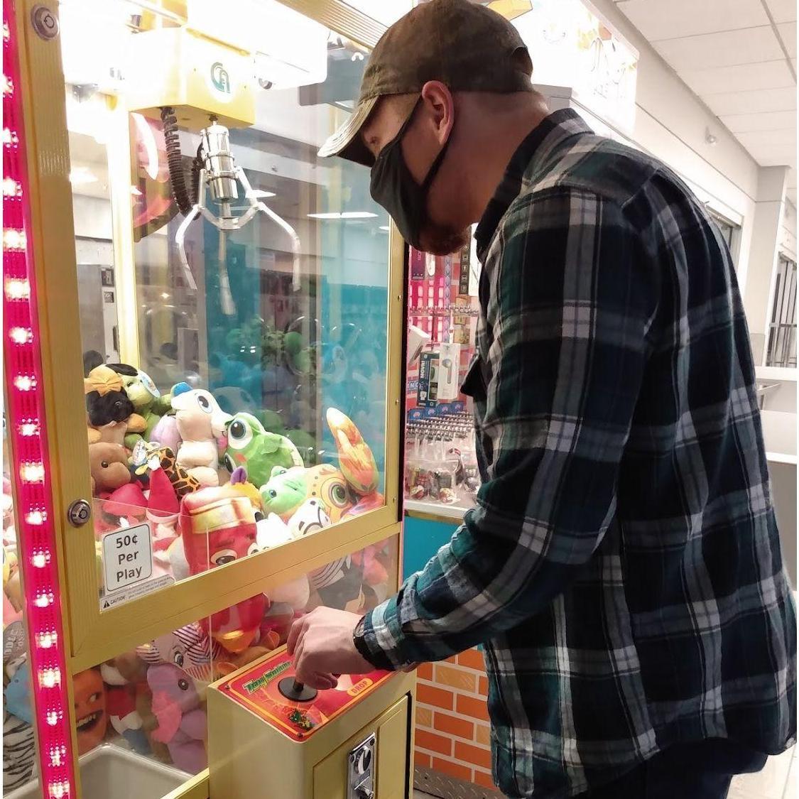 Devon winning Anna a prize from the claw machine at a laundromat
