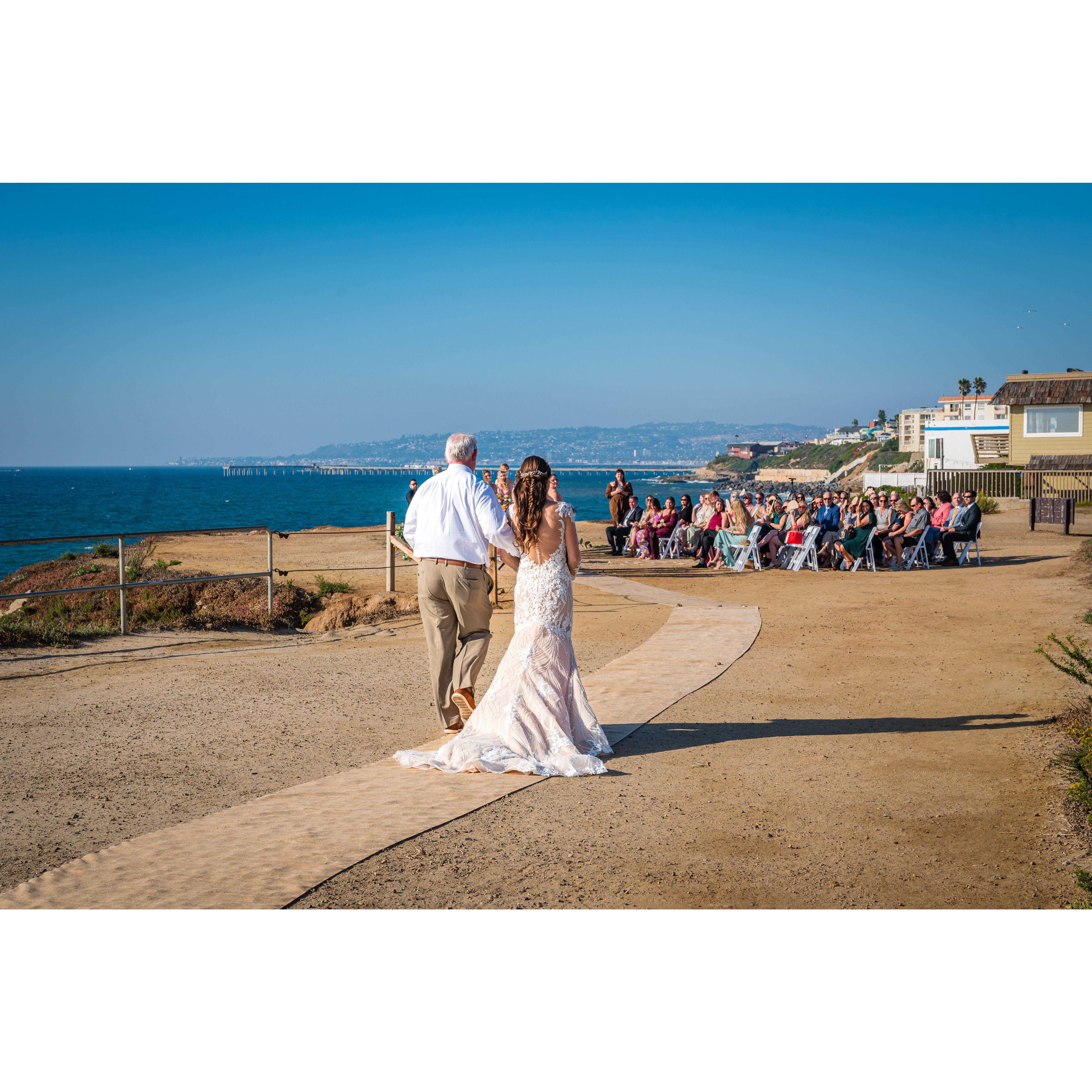 Gracey and her dad walking down the aisle.
