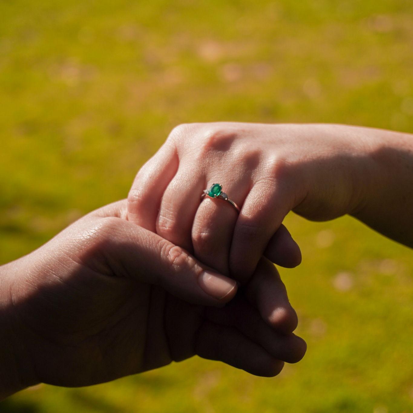 Two pear shaped diamonds and and center oval shaped emerald