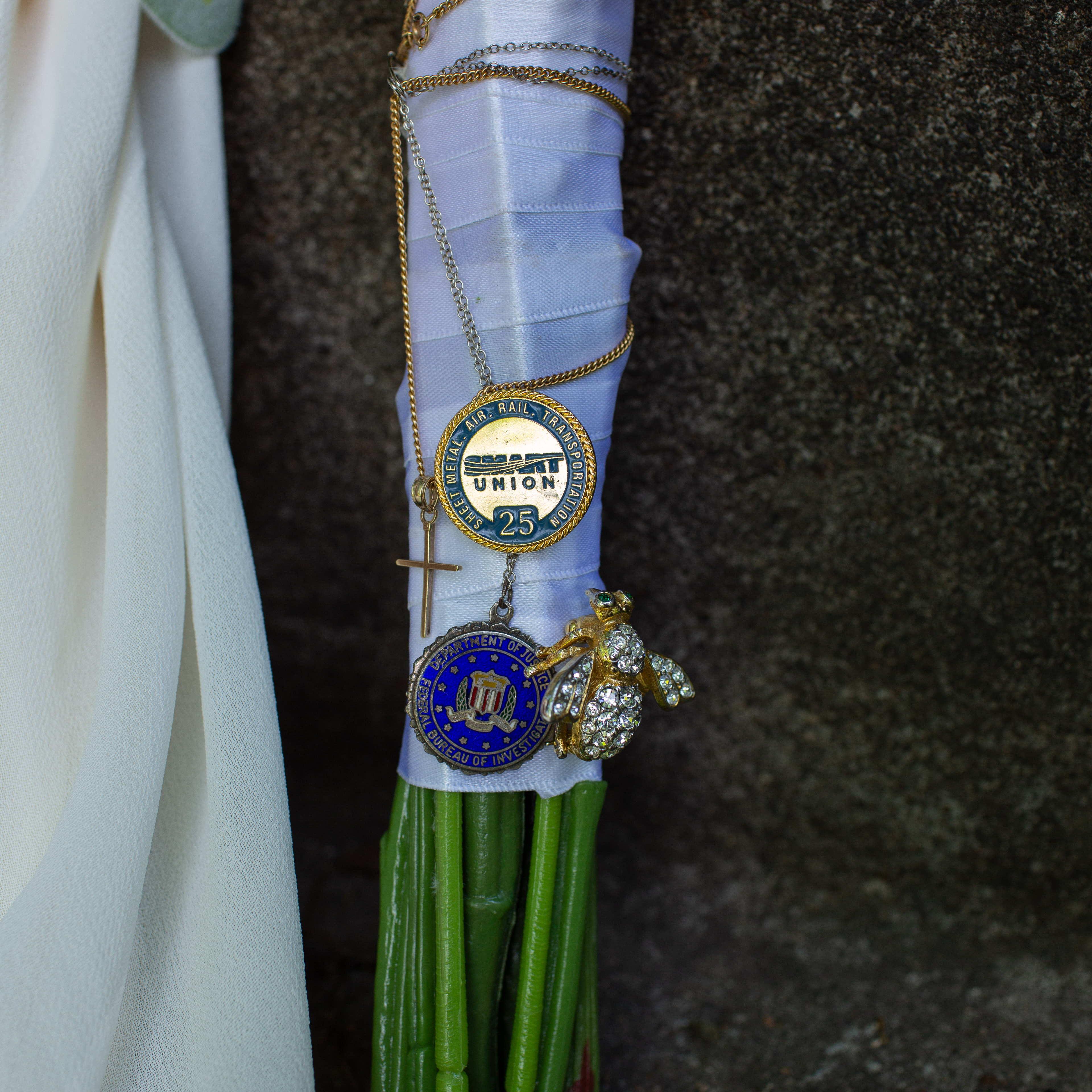 I represented my parents and maternal grandparents on my bouquet: My grandmother's bumblebee broach, my grandfather's FBI medal, my father's union service pin, and my mother's cross necklace.