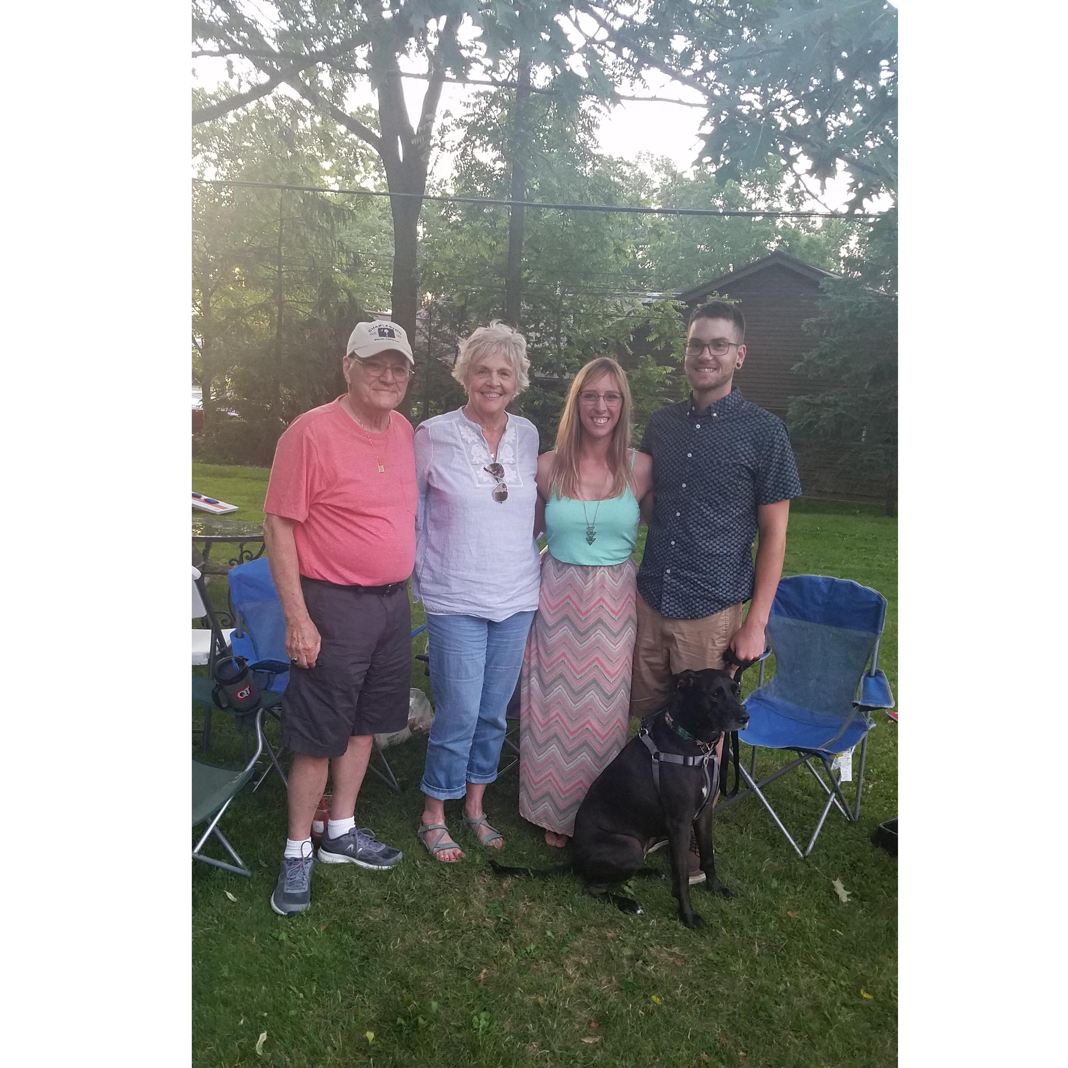 The couple posing with Erika's grandparents at her sister, Emma's, high school graduation.